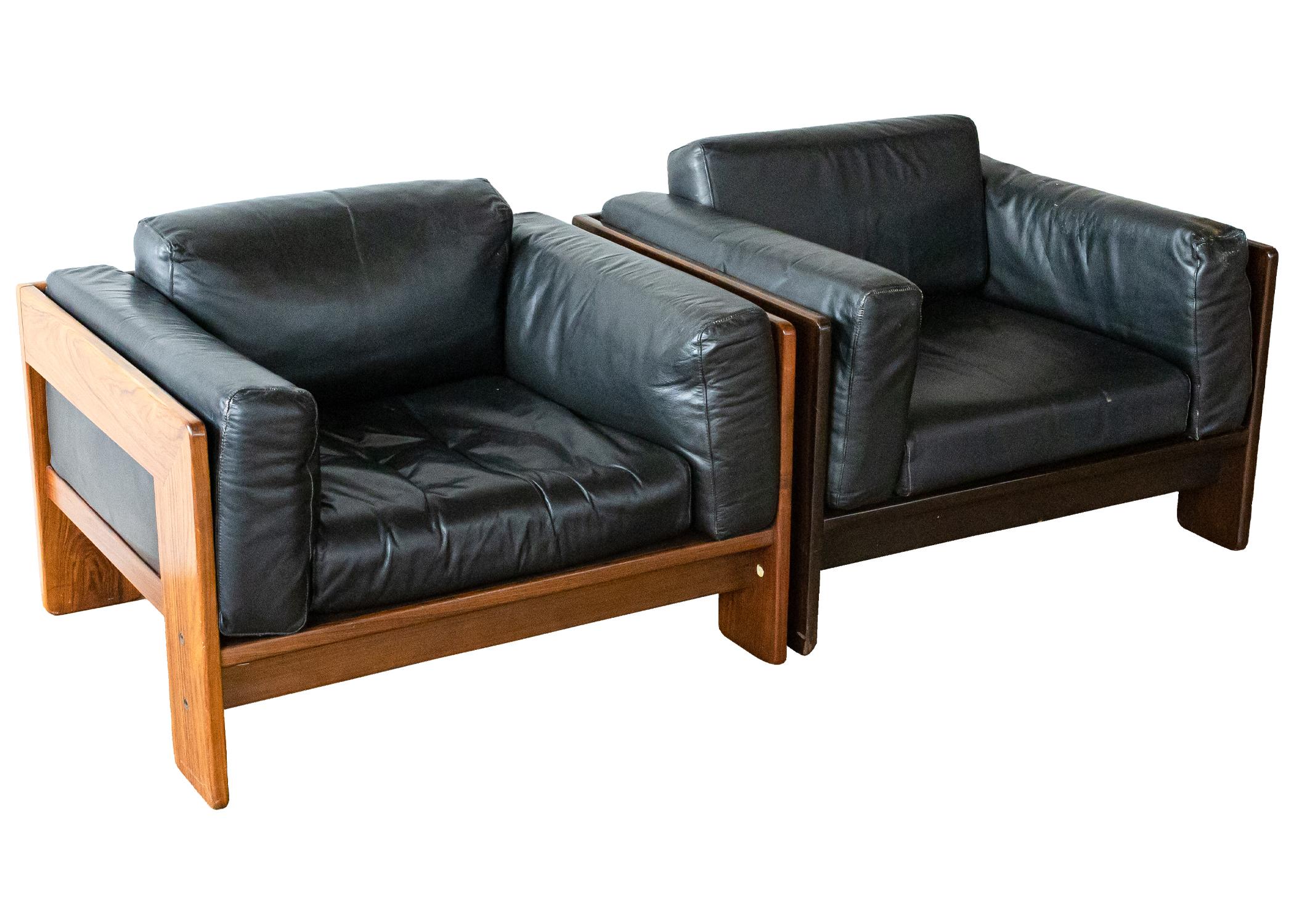 A set of 2 Tobia Scarpa Bastiano rosewood black leather chairs. This stunning set of Bastiano lounge chairs feature a rare rosewood construction. Each chair has a different finish; one light, and one dark. The black leather of both chairs is still