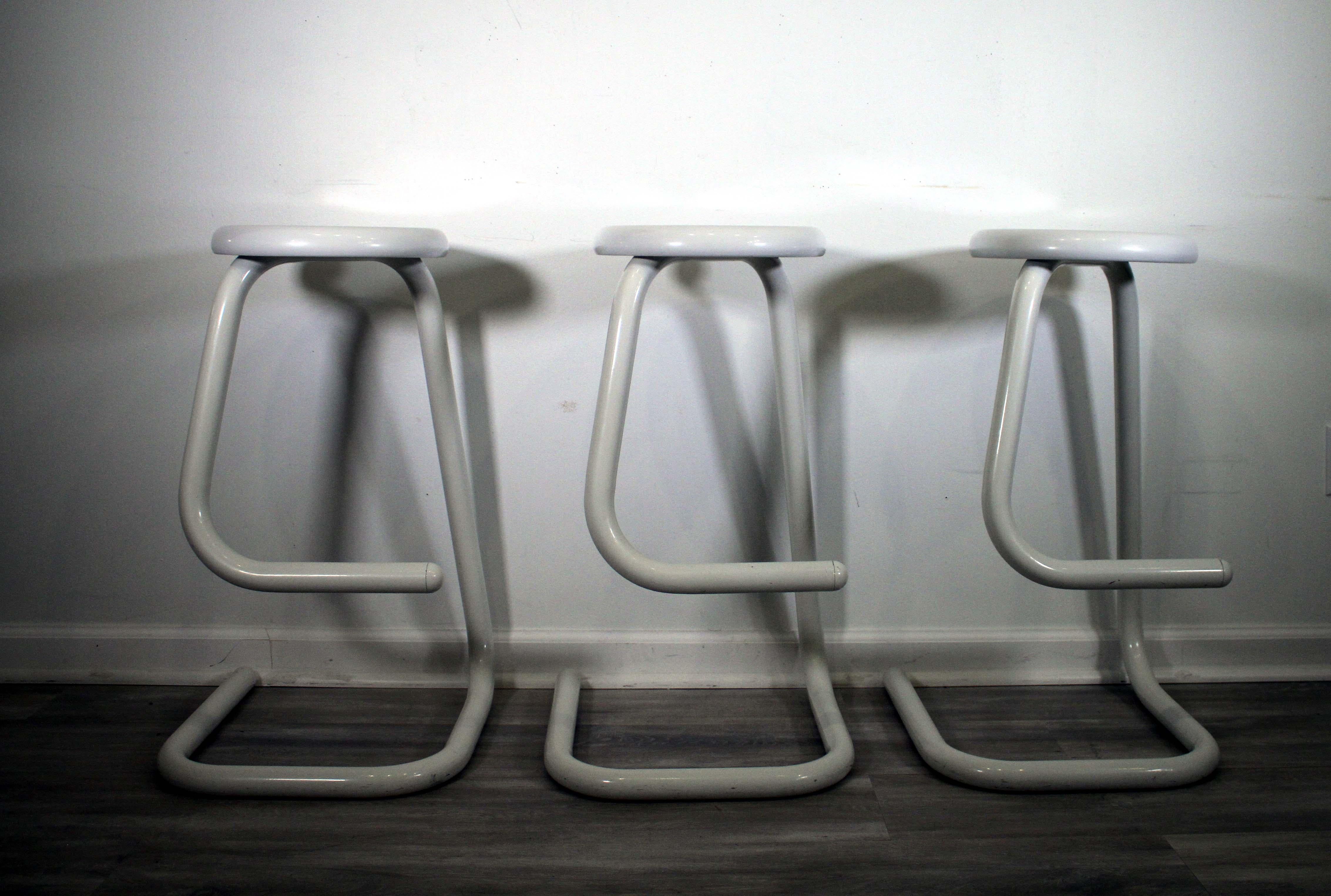 This set of 3 1970s Paperclip Stools by Kinetic is an iconic piece of Mid-Century Modern furniture. Crafted with a sleek, Minimalist design, each stool is constructed from sturdy metal rods and finished in a Classic white. The frame of each stool is