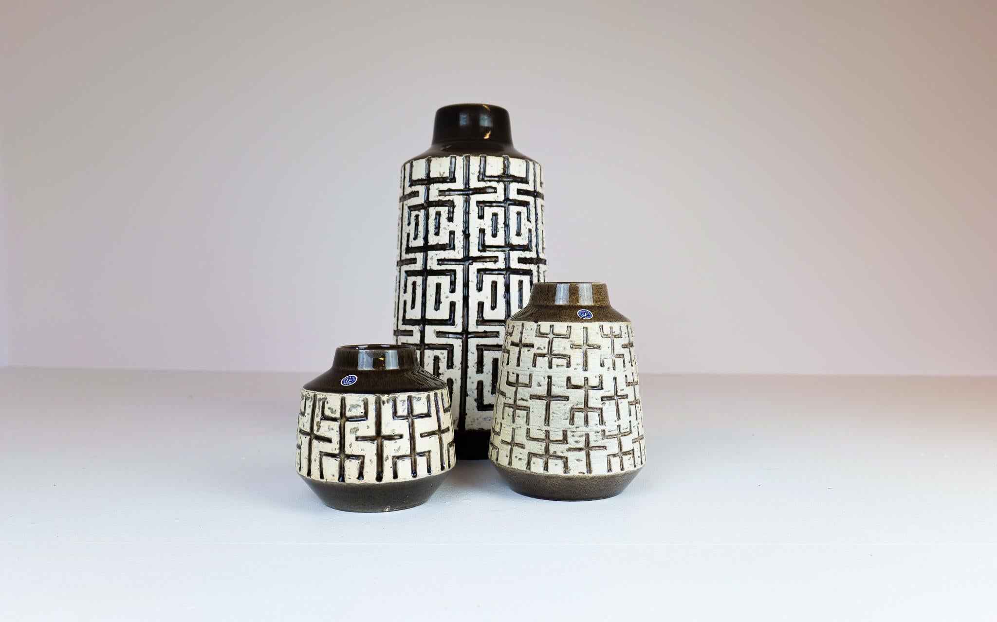 Mari Simmulson is the creator of these vases produced in Sweden at Upsala Ekeby in the 1960s. Wonderful sculptured with a nice pattern with labyrinth reliefs. 

Good condition, the large floor vase with glaze chipped on the bottom