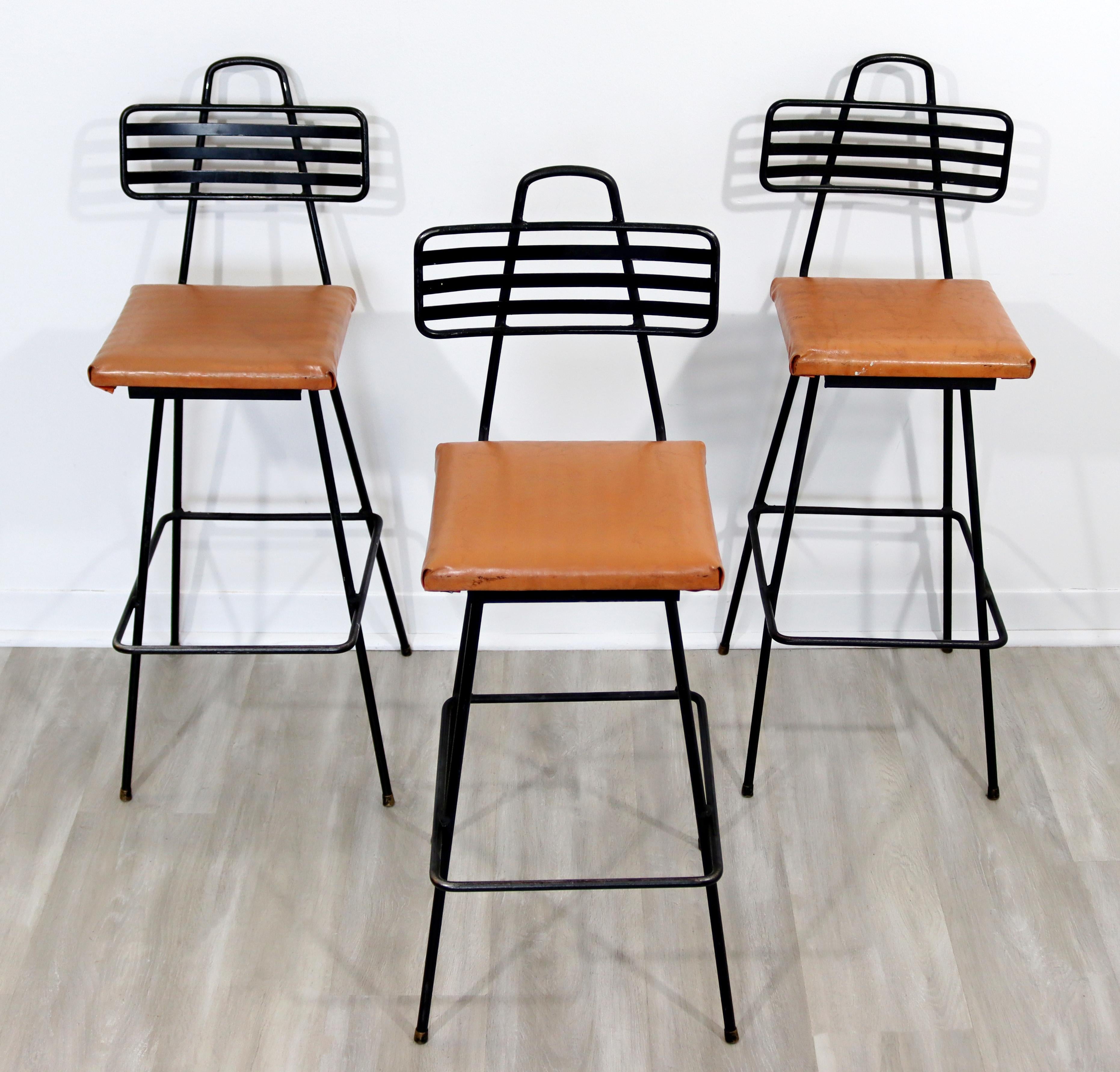 For your consideration is a fantastic set of three wrought iron bar stools, with vinyl seats, by Tony Paul, circa the 1960s. In very good vintage condition. The dimensions are 15