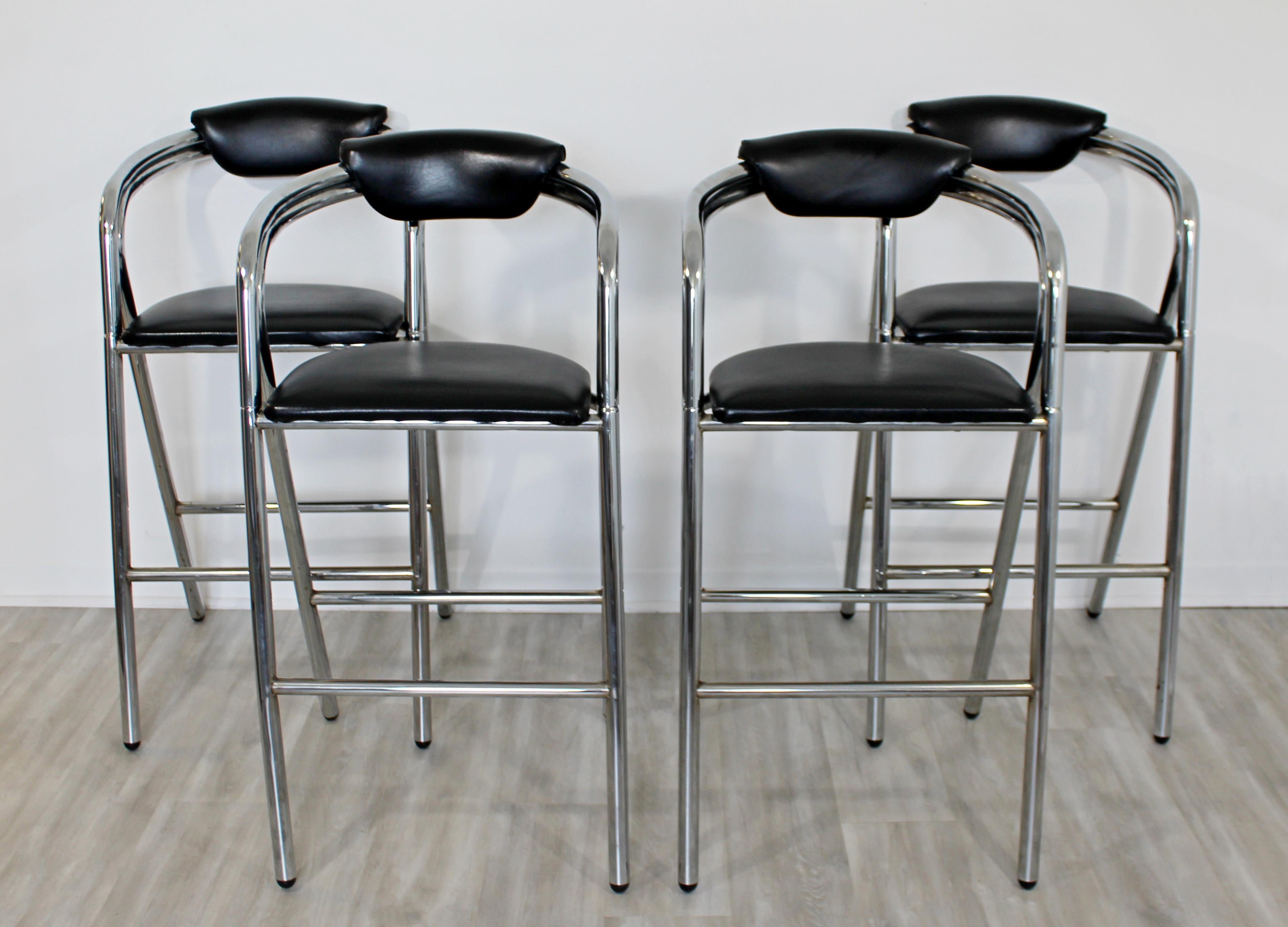 For your consideration is a Classic set of four, tall bar stools, with black leather seats on chrome bases, circa 1970s. In very good vintage condition. The dimensions are 22