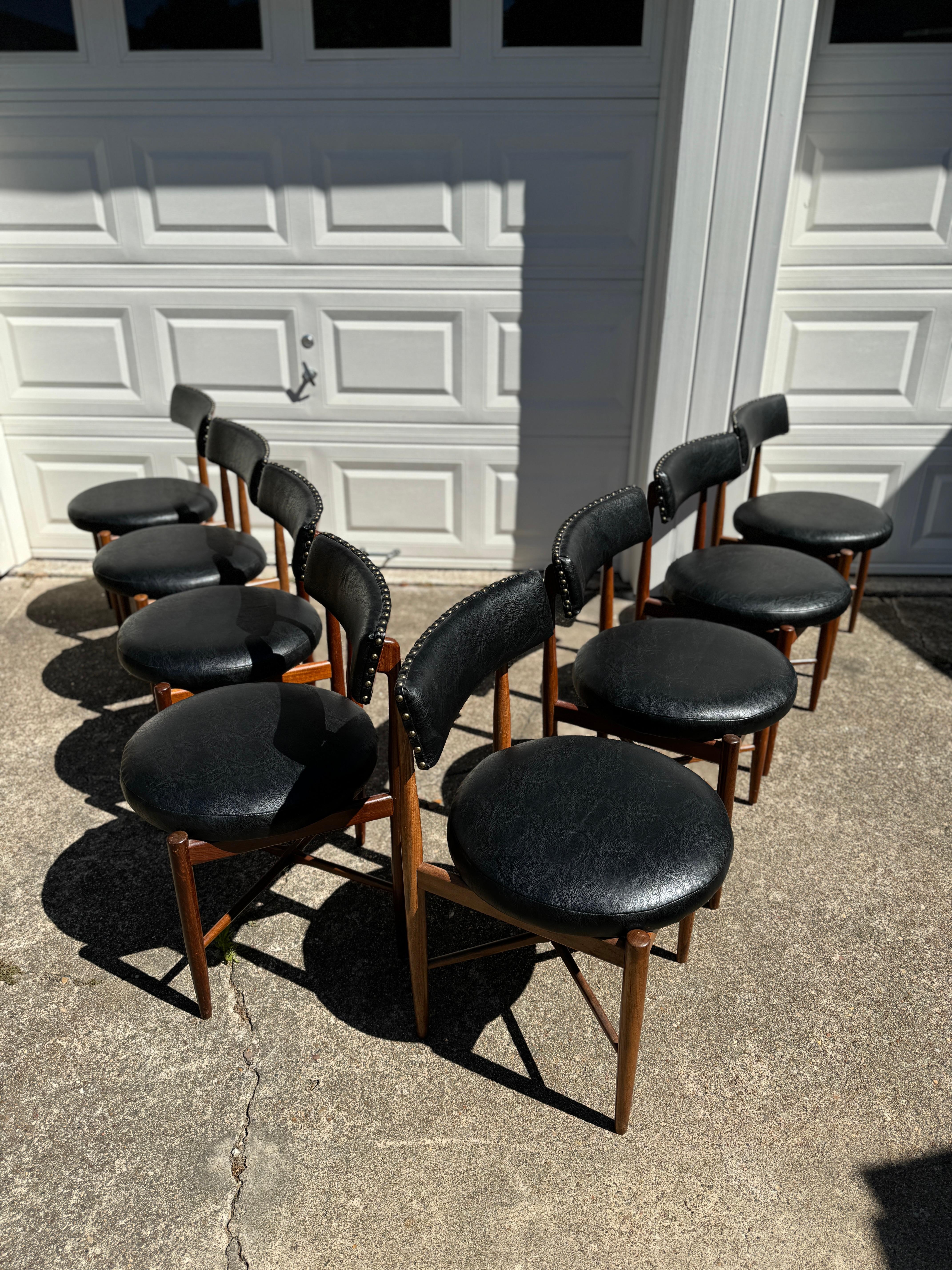 Iconic vintage mid century modern set of 8 dining chairs by Victor Bramwell Wilkins for G plan, circa 1960s. Recently reupholstered in a faux black leather. Frames are structurally sound and all original. Overall in very good condition. 

30” H x