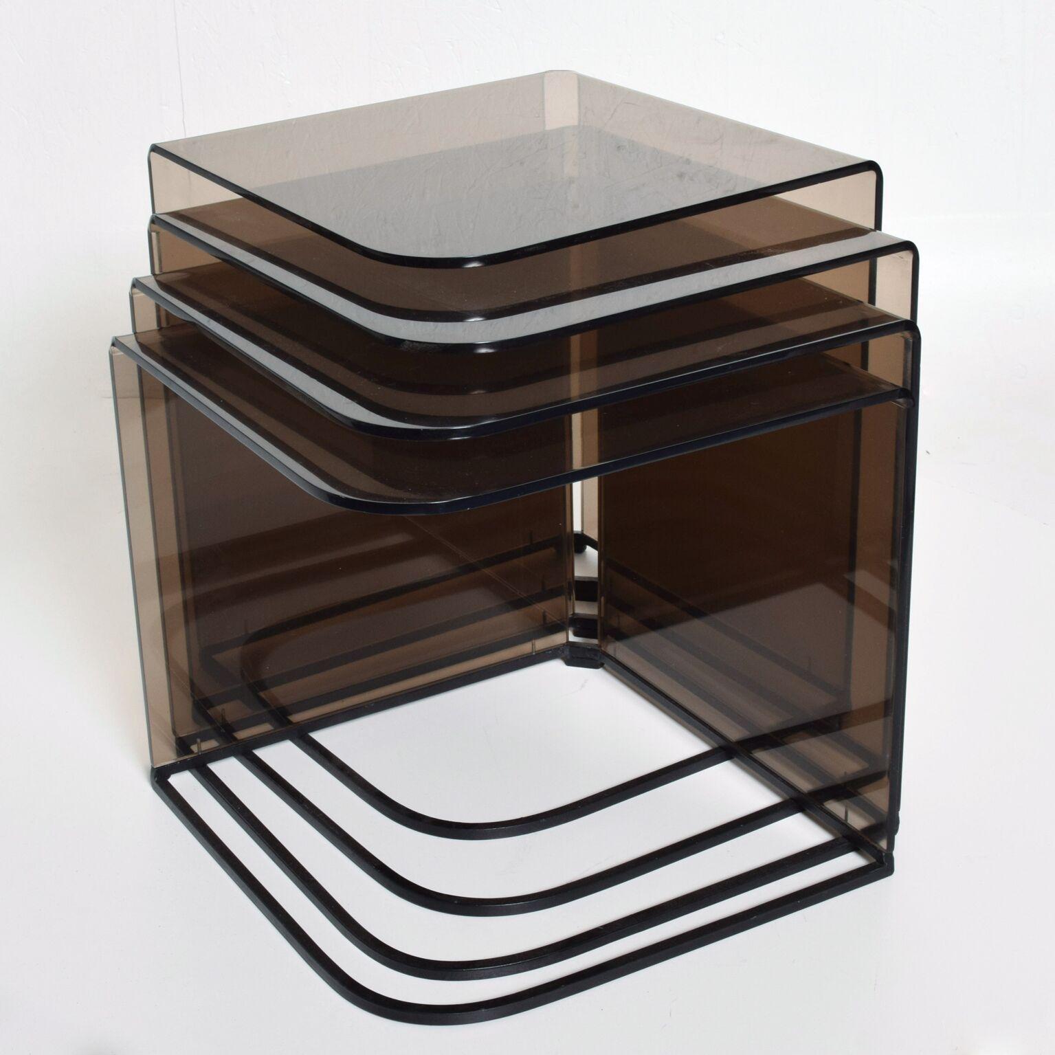 We are pleased to offer you a fantastic set of four (4) nesting tables constructed with the metal frame painted in satin black color and smoke or grey plexiglass. The plexiglass has a sculptural shape bent around corners. Made in the USA, circa