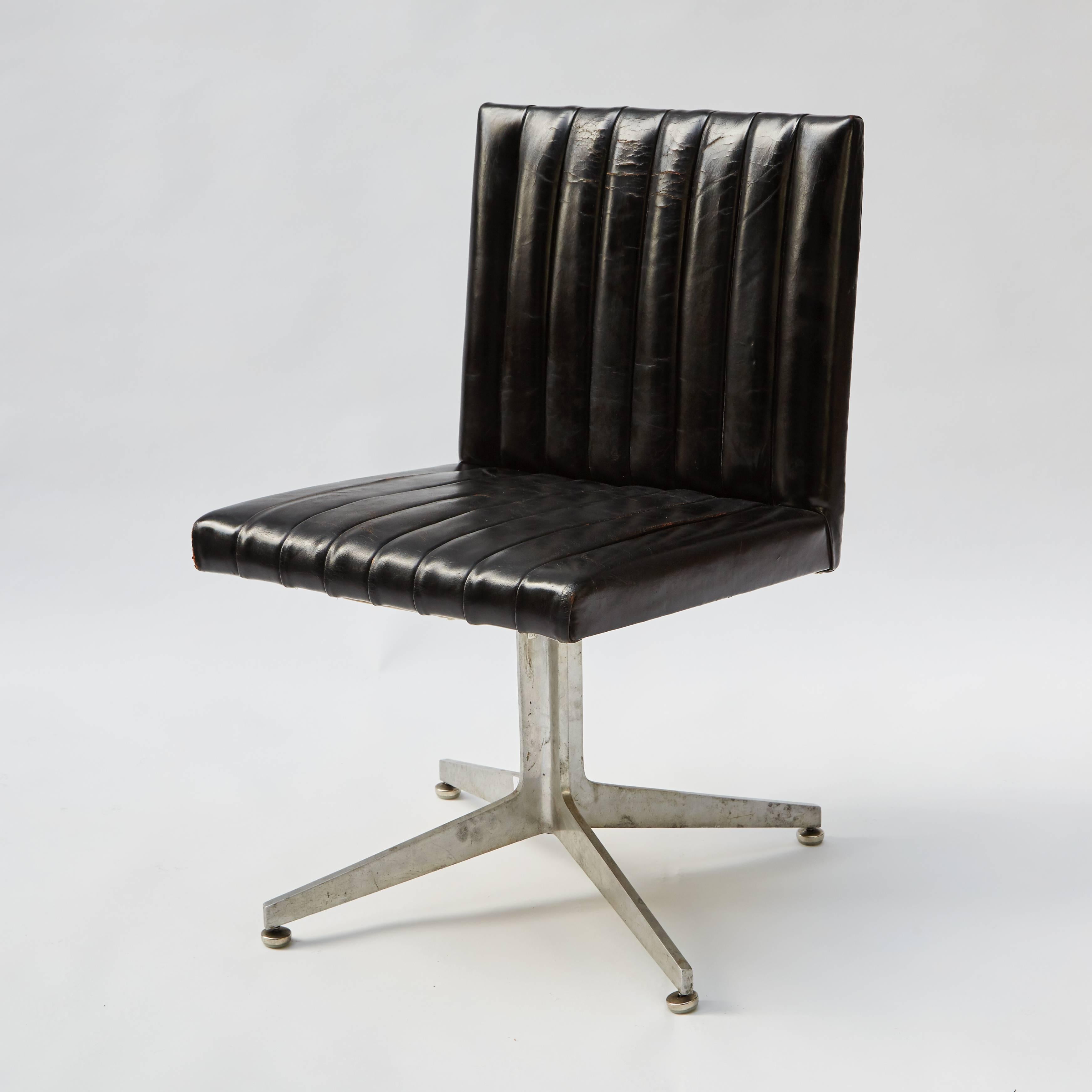 Rare set of four Eames for Herman Miller dining or office chairs. These iconic mid-century modern swivel chairs feature black leather upholstery with stitched vertical patterning along the seat-backs and minimalist chrome spider-foot pedestal bases.
