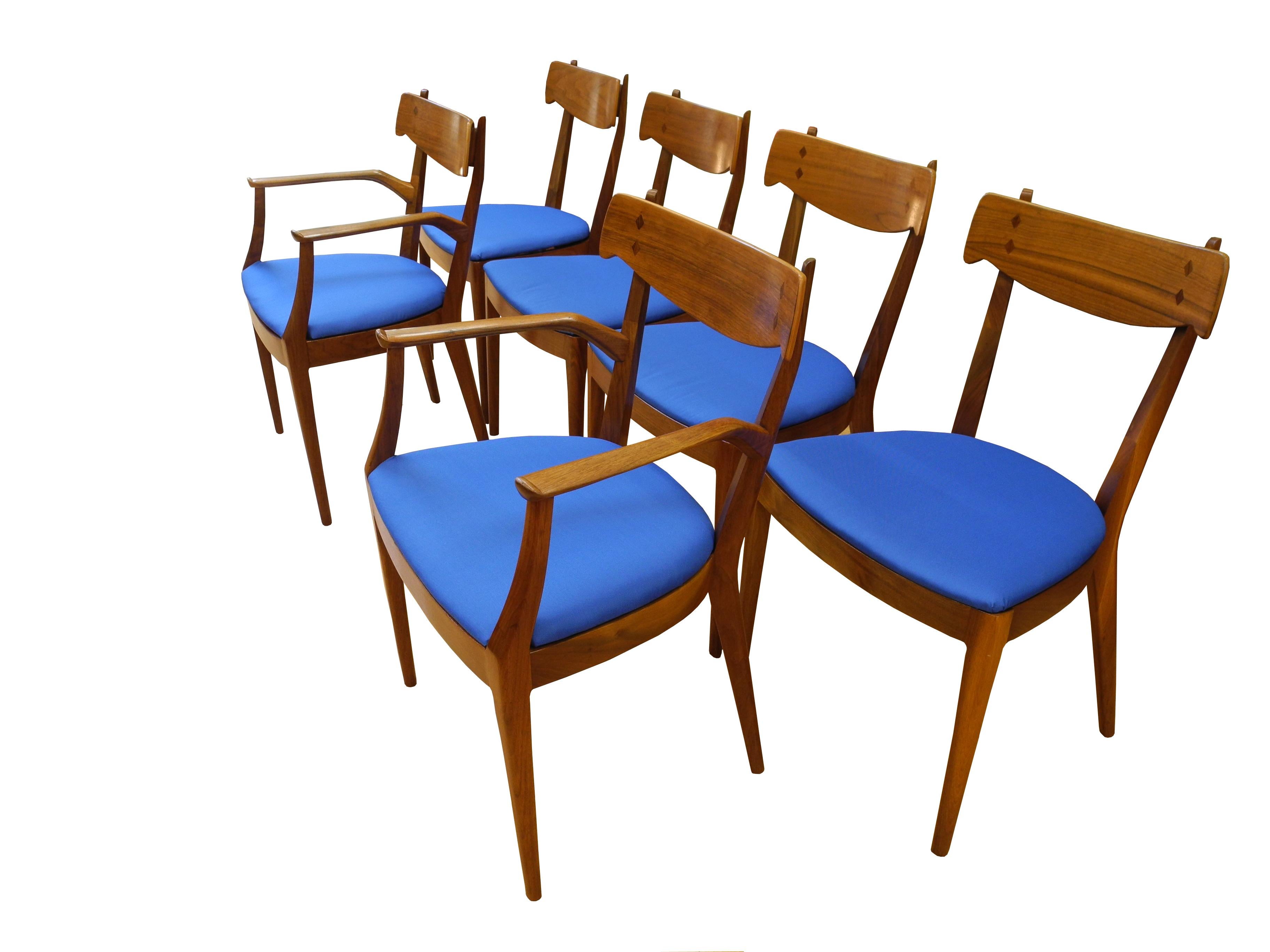 This set of six dining room chairs were designed by Kipp Stewart in the 1950s. The walnut frames have subtle curves and details. There are two armchairs and four side chairs. Sold as a set of six.