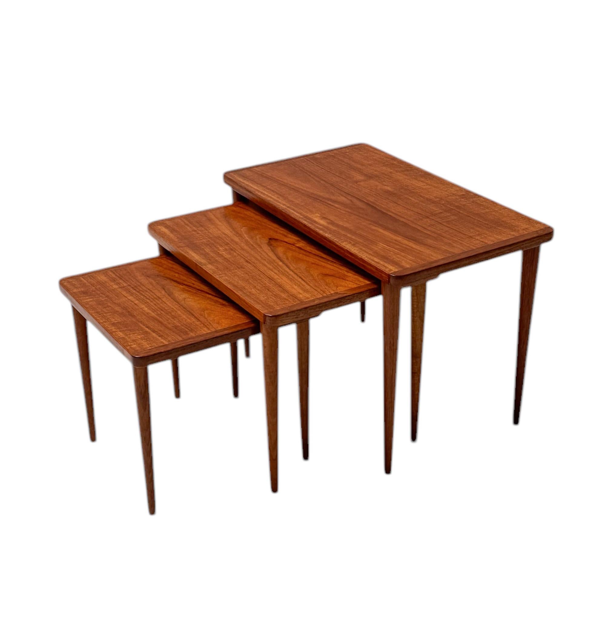 Atemberaubendes und elegantes Set von drei Mid-Century Modern Nisttischen.
Auffälliges dänisches Design aus den 1960er Jahren.
Massive Teakholzbeine und original teakfurnierte Tischplatten.
Dieser wunderbare Satz von drei Mid-Century Modern