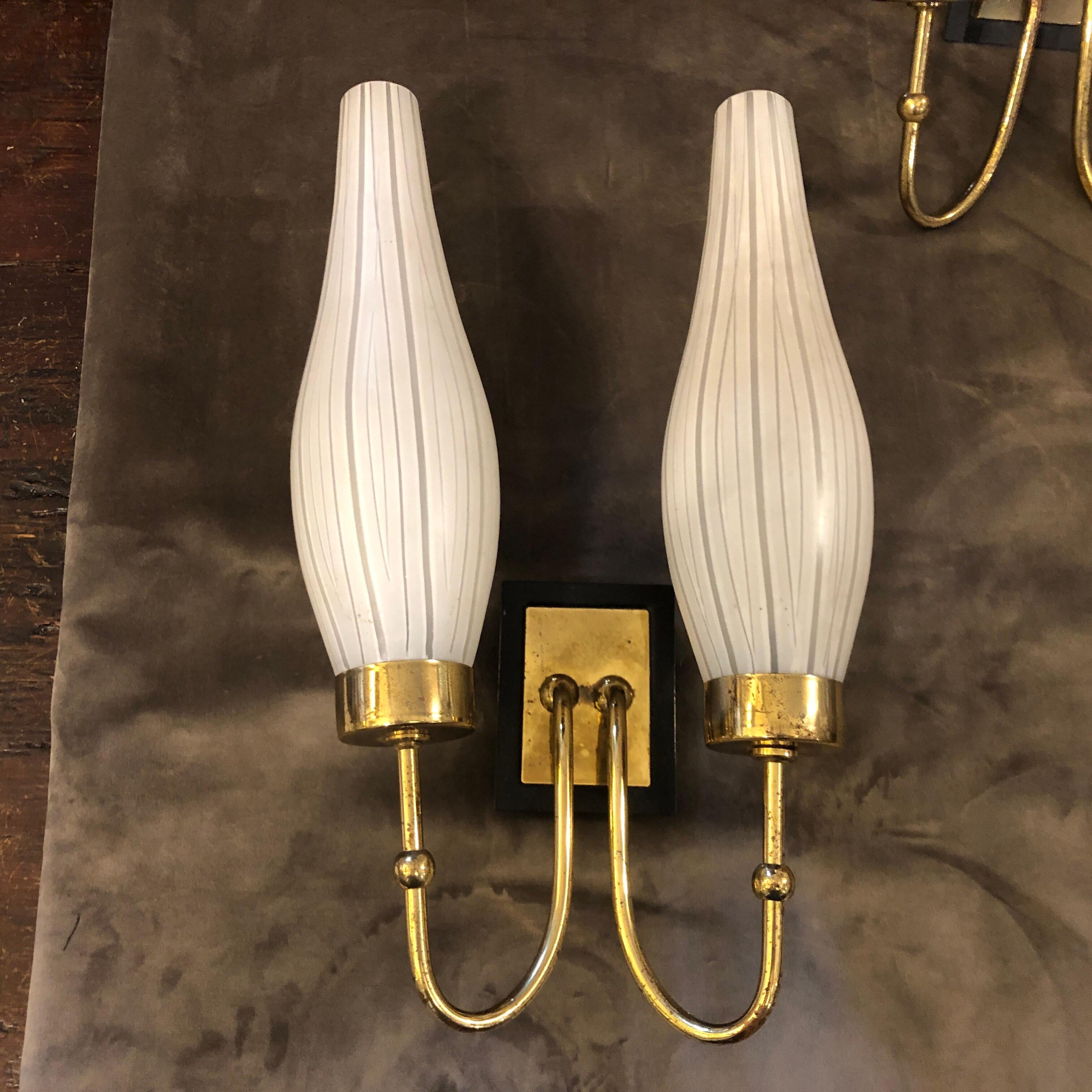 Two Mid-Century Modern brass and striped white murano glass wall sconces designed and manufactured in Italy in the 1950s, they work 110-240 volts and need regular e14 bulbs. Brass is in original patina and that creates a good vintage look.