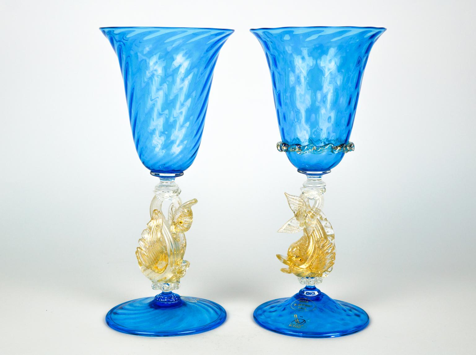 Elegant pair of aquamarine glass goblets with dolphin and swan in 24-carat gold leaf. 
The objects made of Murano glass are all handmade by our famous Murano artisans, making our works unique and inimitable. 

The goblets was made in the Murano