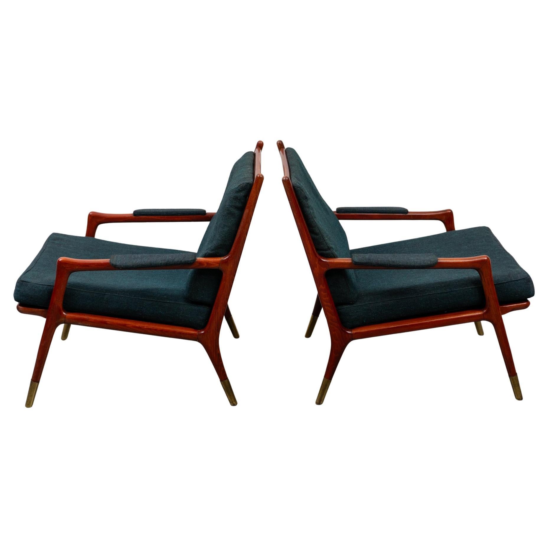 Ensemble de deux chaises longues en noyer et éléments en laiton conçu et fabriqué au Danemark. Les deux chaises sont en bon état d'origine, la structure est conçue en noyer avec des accoudoirs aux formes gracieuses et des éléments en laiton au