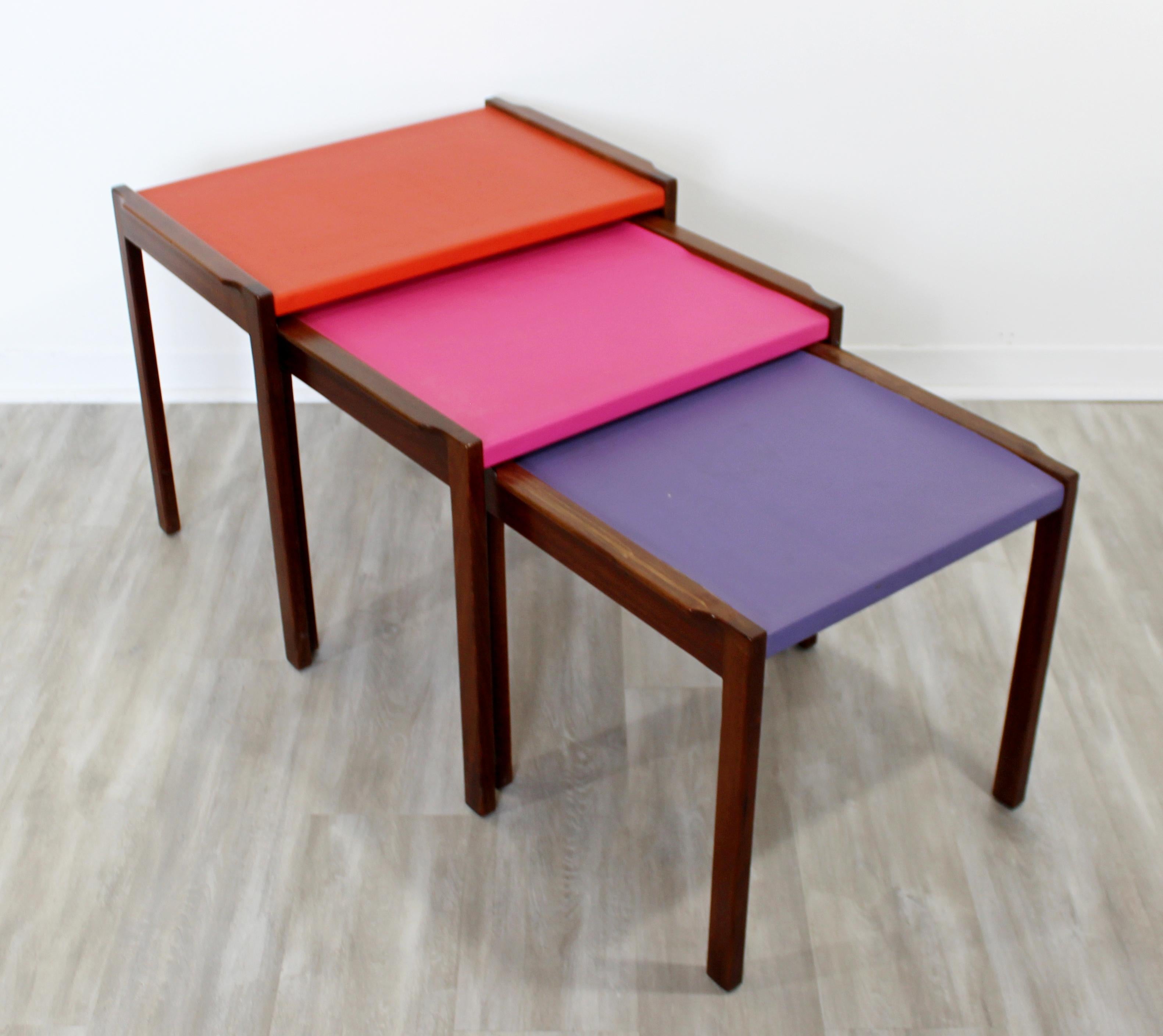 For your consideration is a fabulous and fun set of three nesting tables, made of walnut and multicolored vinyl tops, by Jens Risom, circa 1960s. In excellent condition. The largest table measures: 26