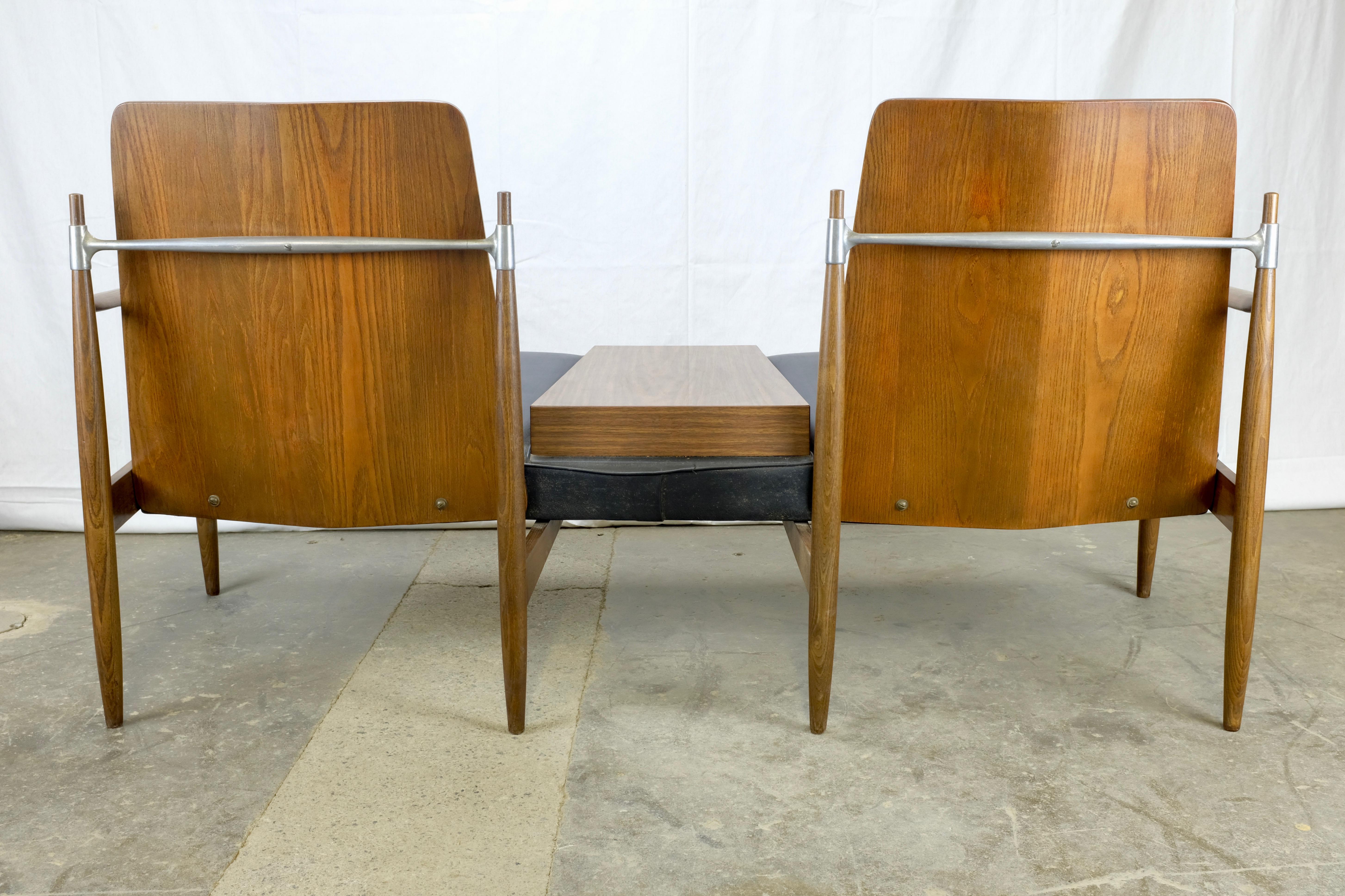 Unique Mid-Century Modern bench or settee featuring two cushioned seats and molded plywood backs with upholstered cushions. Between the seats there is a walnut veneered surface for resting drinks, snacks or reading material.

The backside has a