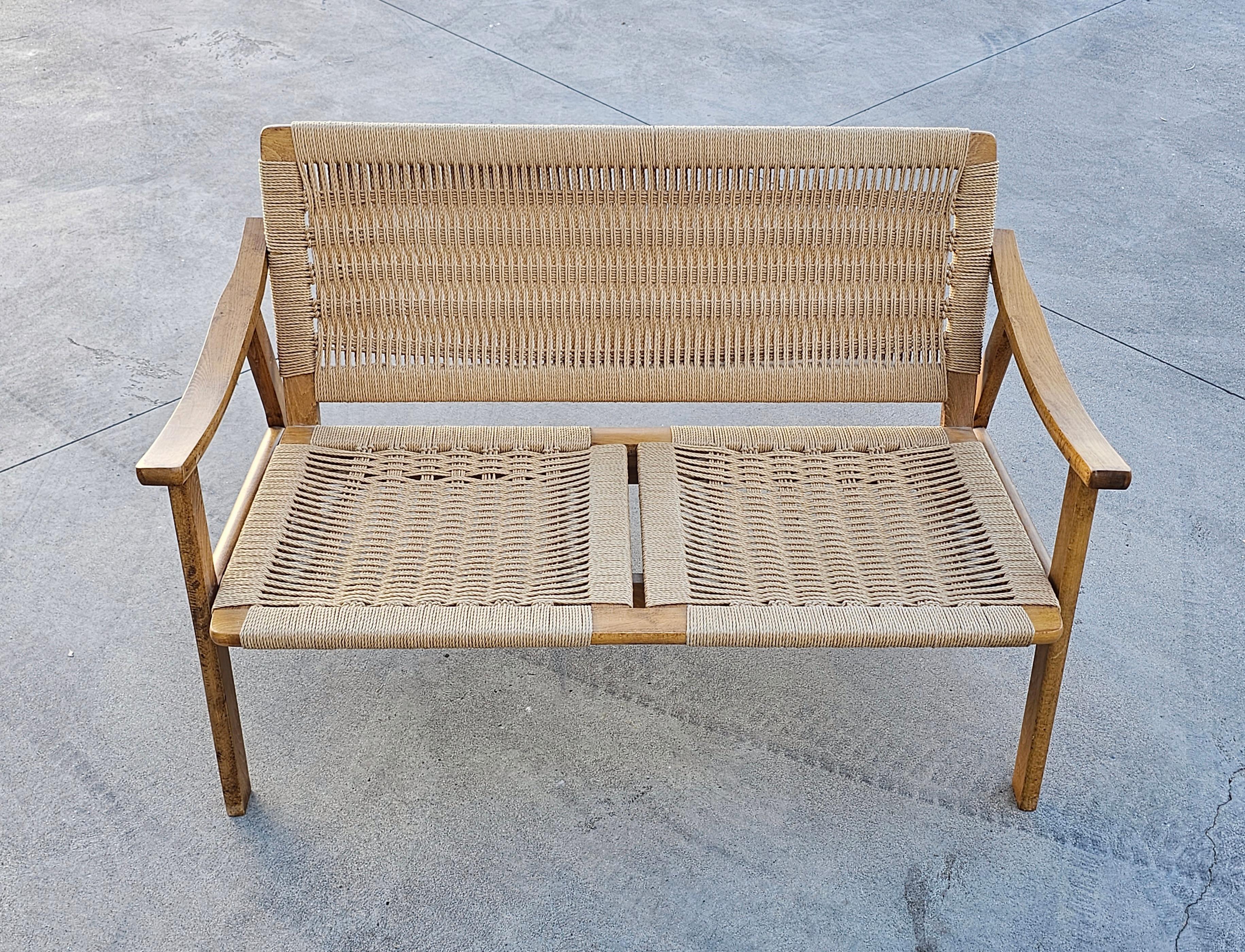 In this listing you will find a gorgeous and very rare two seater sofa or a settee done in oak with Danish paper cord hand-woven seats and backrests. The settee is done in style of Hans J. Wegner and it was manufactured in Yugoslavia in 1960s.

Very