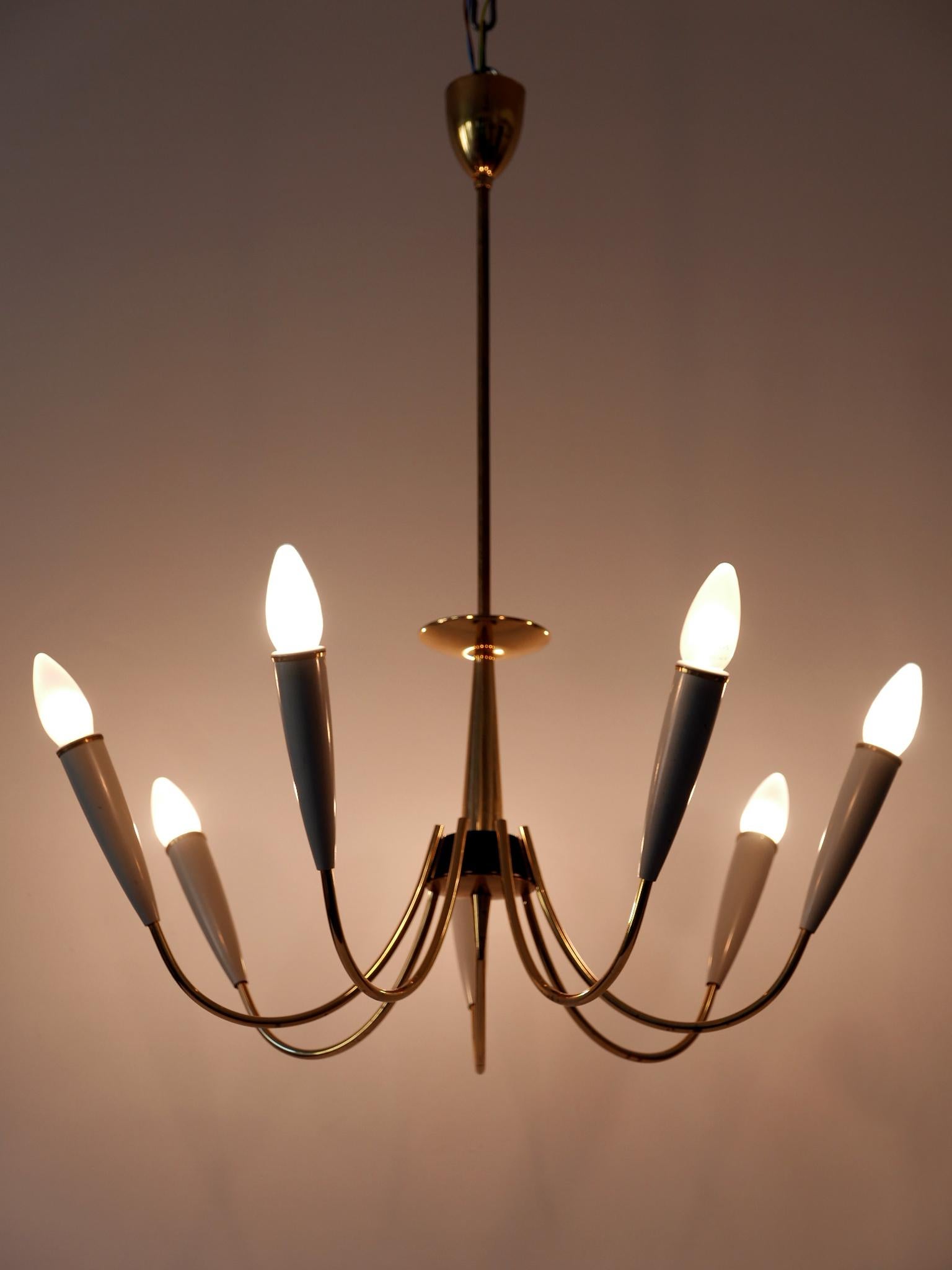Elegant Mid-Century Modern seven-armed sputnik chandelier or pendant lamp. Designed and manufactured in Germany, 1950s.

Executed in brass and bakelite, the lamp needs 7 x E14 / E12 Edison screw fit bulbs. It is wired, in working condition and