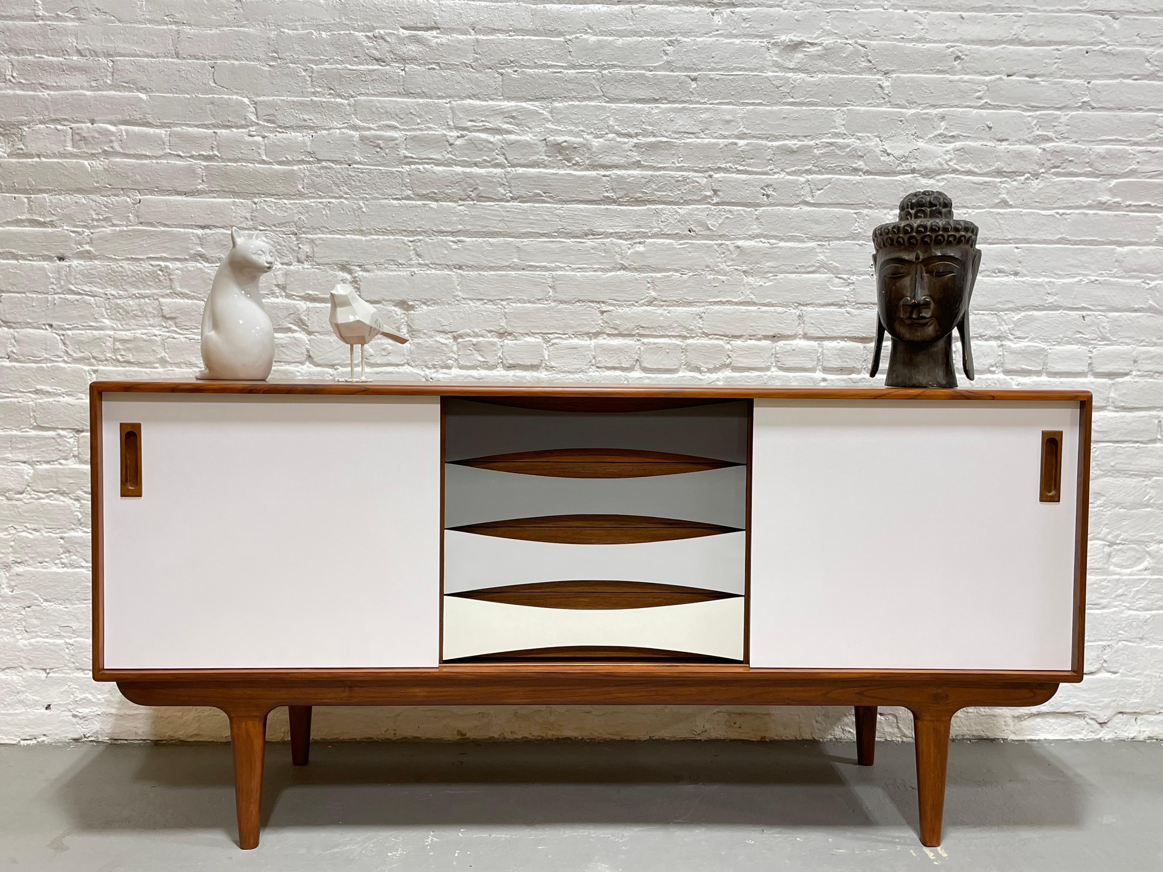 Our Mid-Century Modern styled HANDMADE “Shades of Gray” credenza offers a stunning combination of center drawer space and adjustable shelving along each side. This gorgeous piece is finished with thin sheets of colored laminate over solid wood –