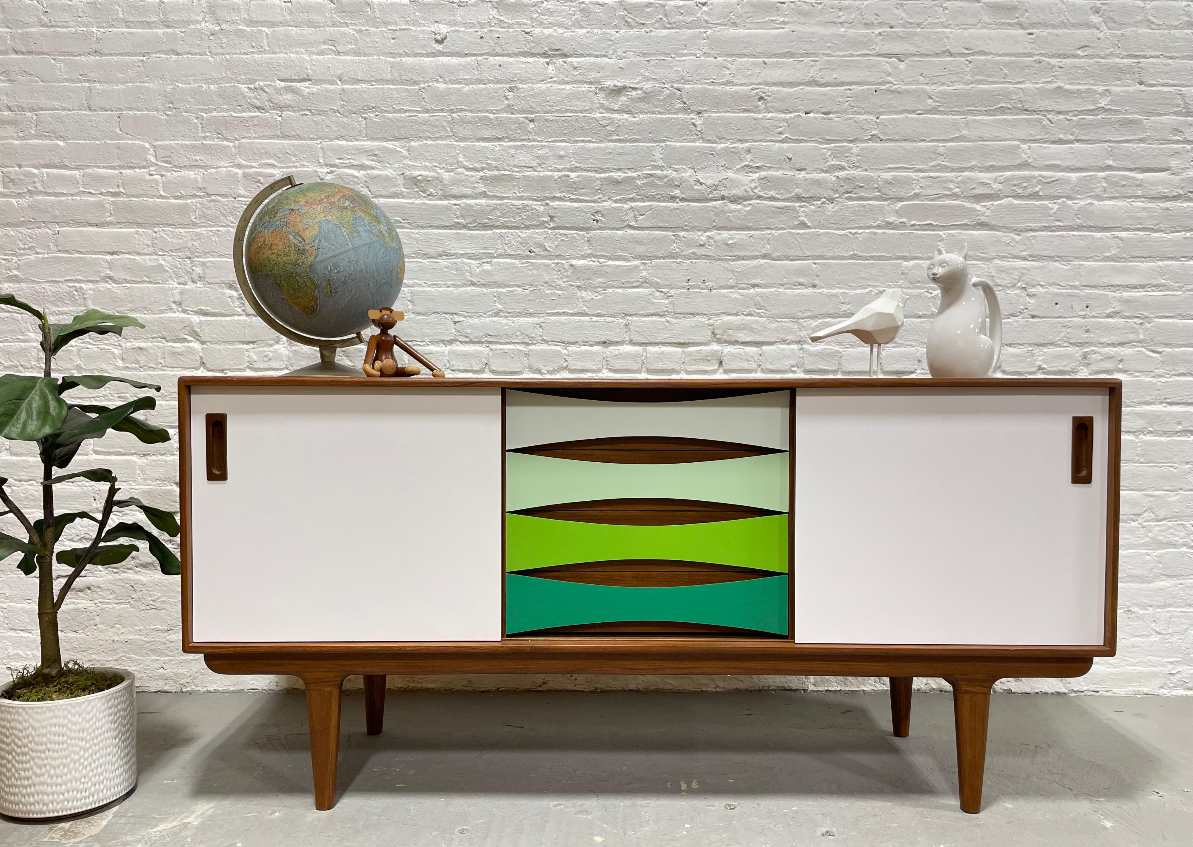 Our Mid-Century Modern styled HANDMADE “Shades of Green” credenza offers a stunning combination of center drawer space and adjustable shelving along each side. This gorgeous piece is finished with thin sheets of colored laminate over solid wood –