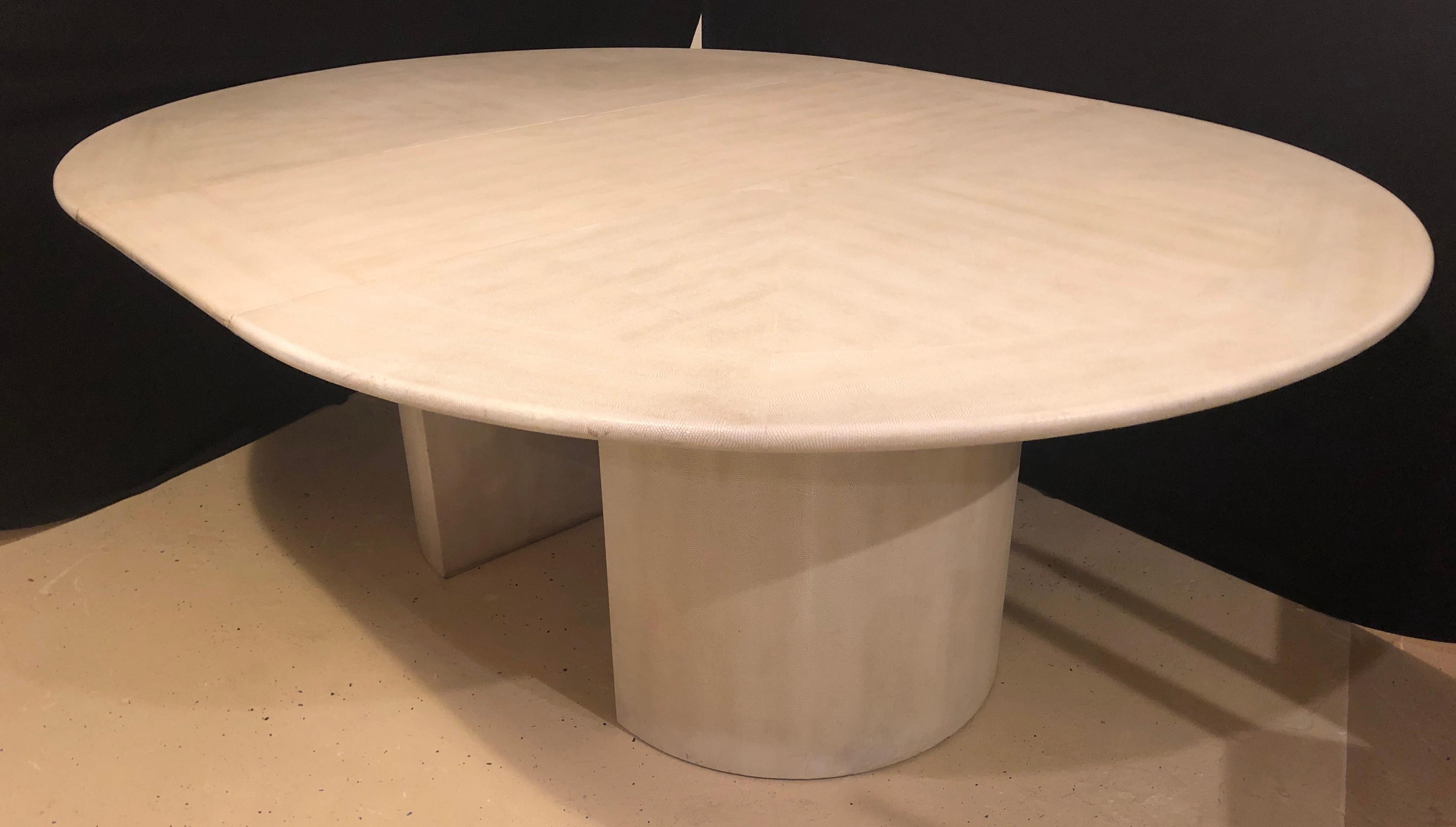 A Mid-Century Modern Karl Springer circular dining, conference or center table having three twenty inch leaves. Part of our extensive collection of over forty dining tables and chair sets as seen on this site, thus why we are referred to as the King