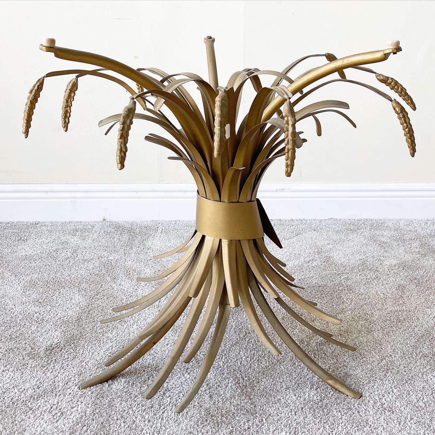 Mid 20th century sculptural gilt metal sheaf of wheat table with a round glass top. Styled after the famous Coco Chanel table this all original vintage table features a tall sheaf of gilt metal wheat with tips of wheat exploding from the base upward