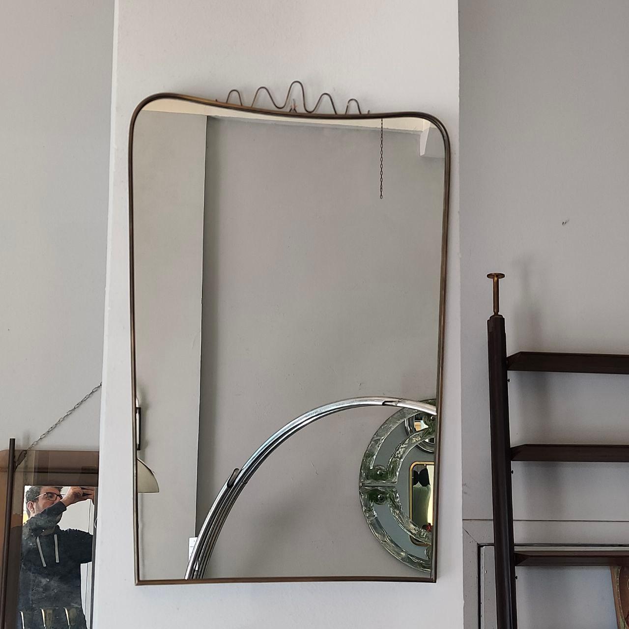 Exemple exquis du design moderne italien du milieu du siècle, ce miroir mural est attribuable à Gio Ponti, vers les années 1950. Son cadre est fait d'un seul tube de laiton ondulant - signature de l'approche innovante de Ponti - fini dans une patine