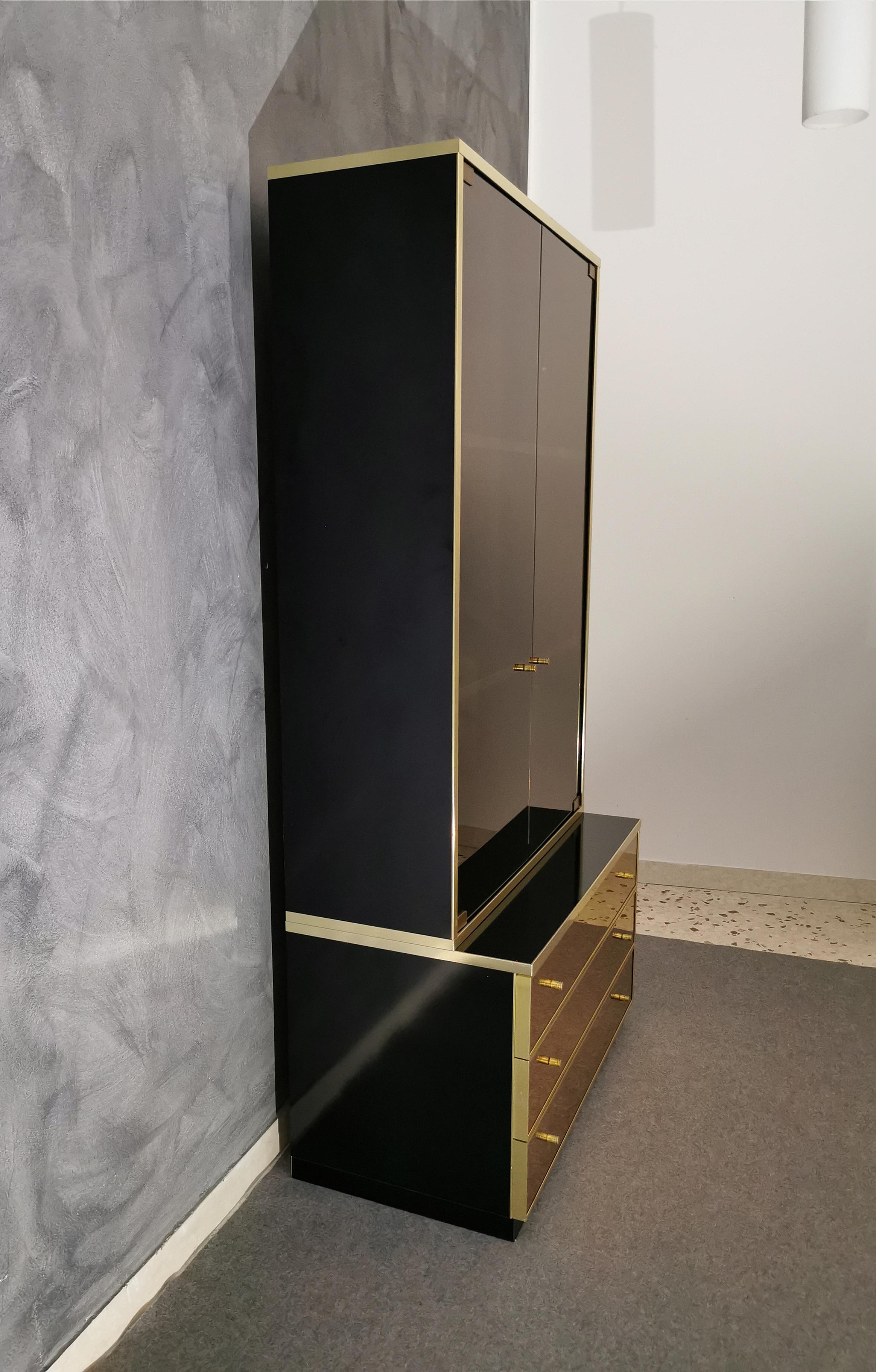 Elegant two-door display cabinet in dark glass by Renato Zevi with brass finishes and interior covered in black suede. The chest of drawers has bronzed mirrored glass with sand-colored suede internal parts. Structure in black lacquered wood, 1970s.