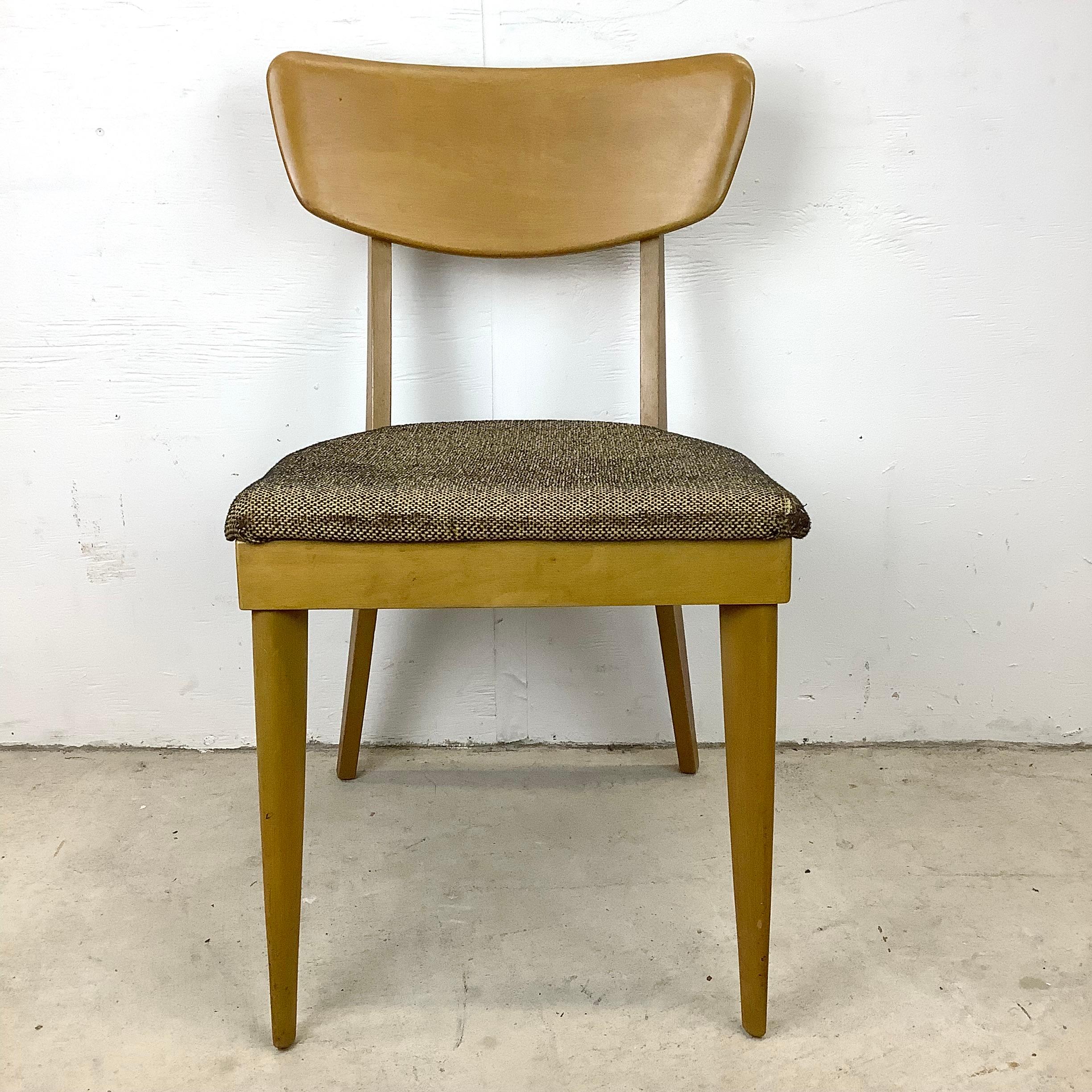 This stylish Mid-Century Modern side chair from Heywood Wakefield features unique sculptural seat back and comfortable upholstered seat. The sturdy vintage birch construction and eye-catching design makes this a perfect addition to any interior,