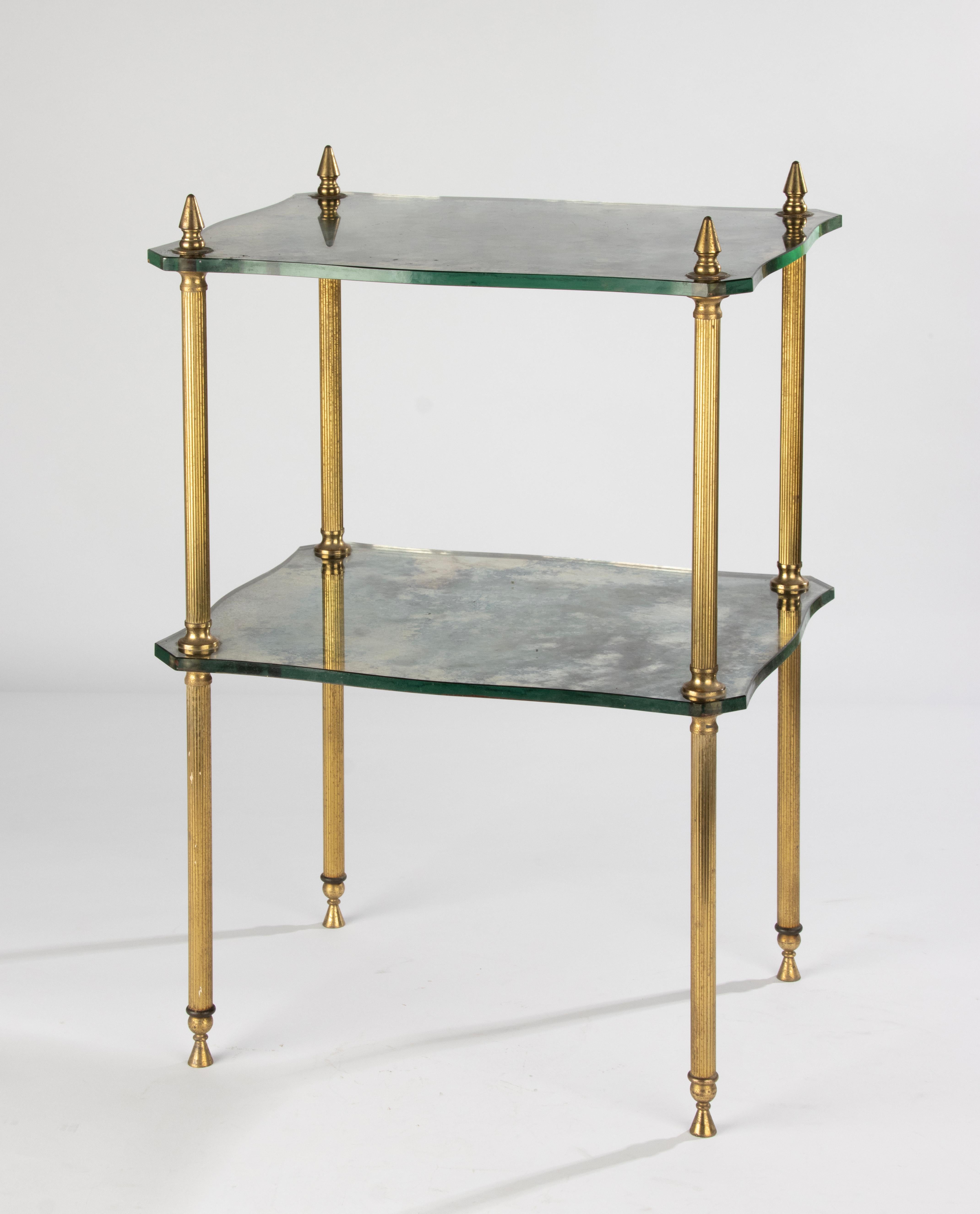 A beautiful two-tier side table, made of brass colored metal and thick glass shelves. 
The glass shelves have a clouded pattern and beautiful shaped edges. 
The table is in good condition, it is sturdy and stable. The clouded glass is original and