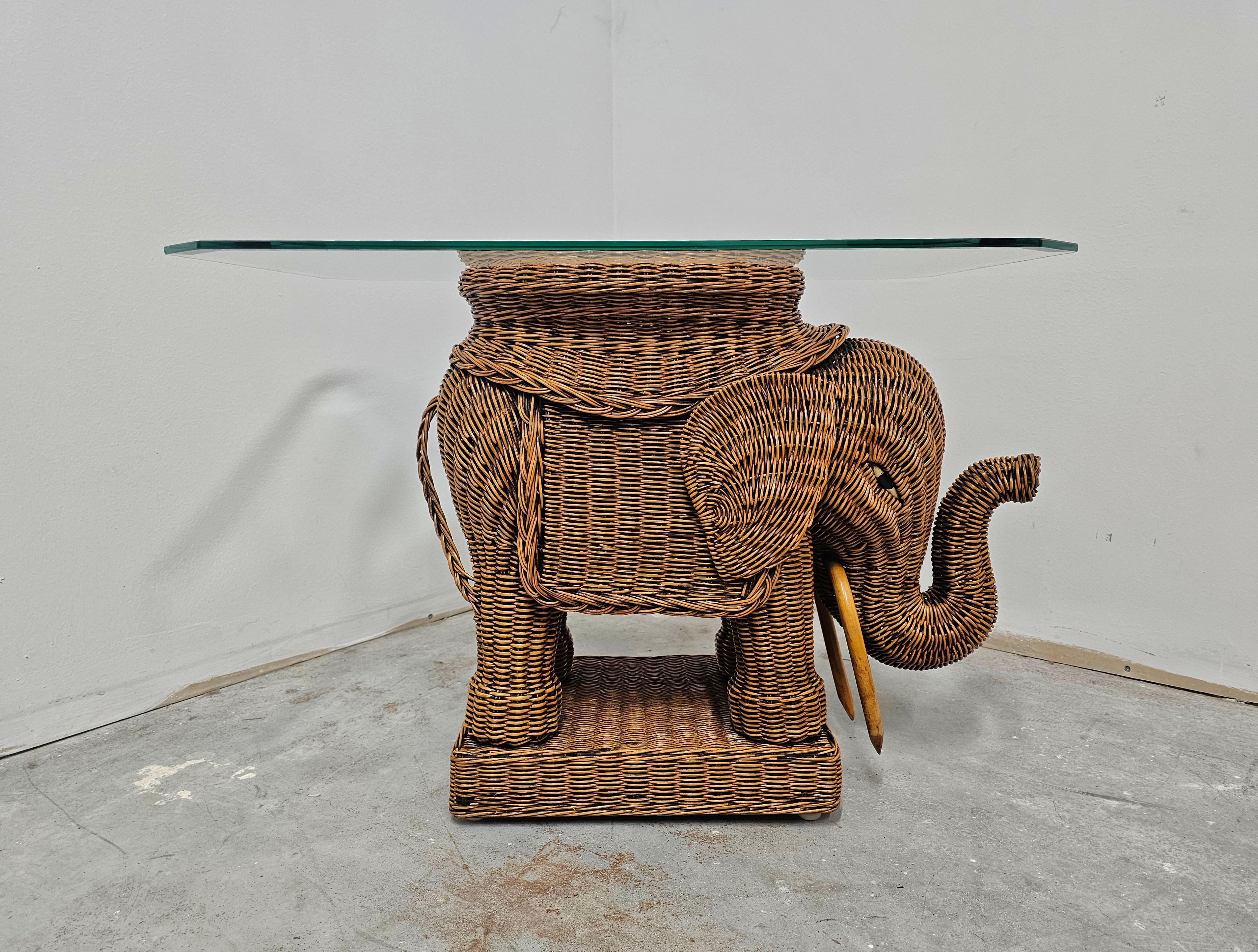Dans cette annonce vous trouverez une très rare table d'appoint Mid Century Modern en rotin attr. au célèbre fabricant de meubles en osier Vivai del Sud. Le rotin est tressé en forme d'éléphant, avec le plateau en verre à facettes, ce qui fait de