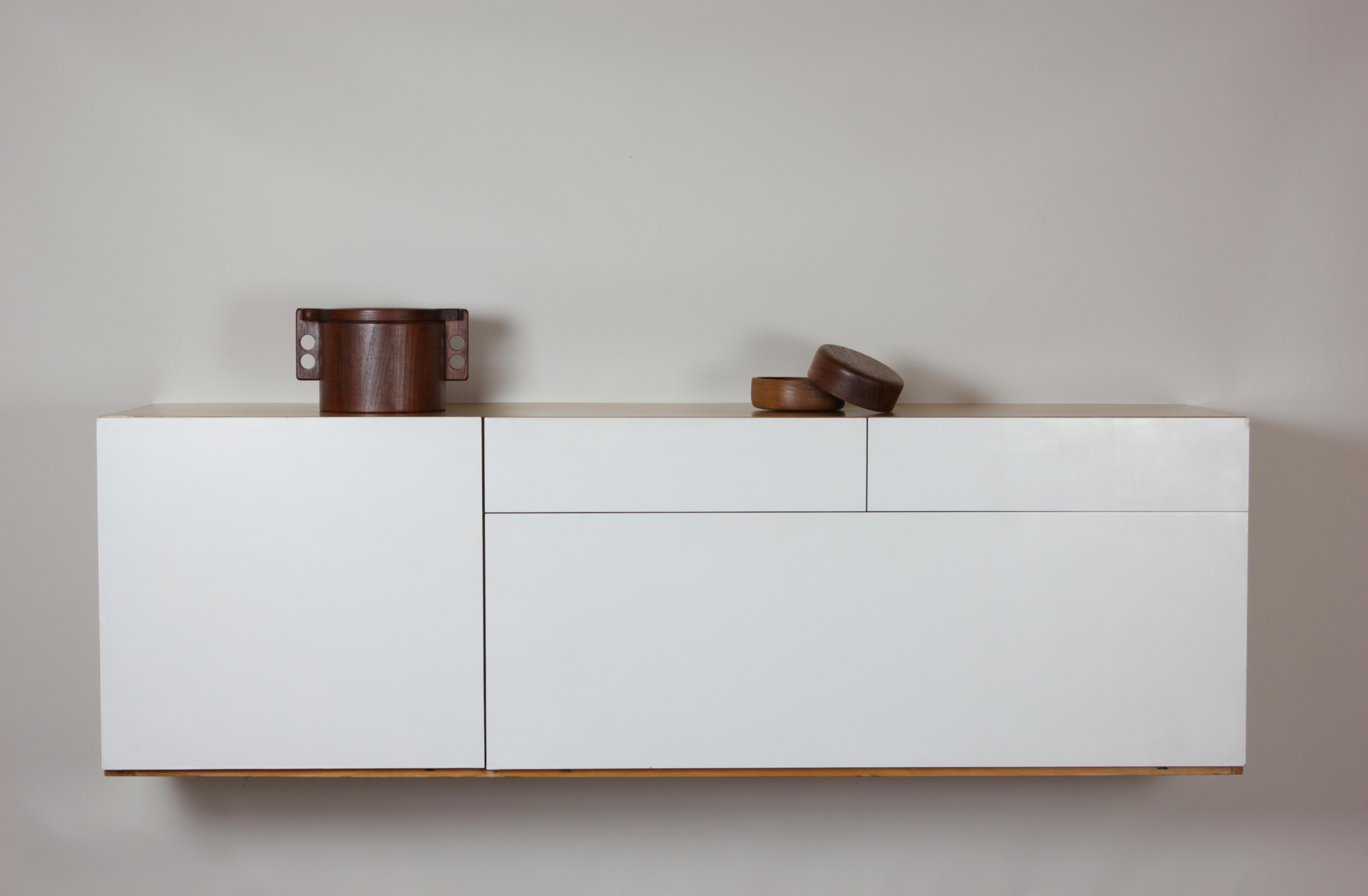 The 1950s wall mounted sideboard designed by the visionary French duo Antoine Philippon and Jacqueline Lecoq is a striking example of mid-century modern design innovation. This exquisite piece seamlessly marries form and function, epitomizing the