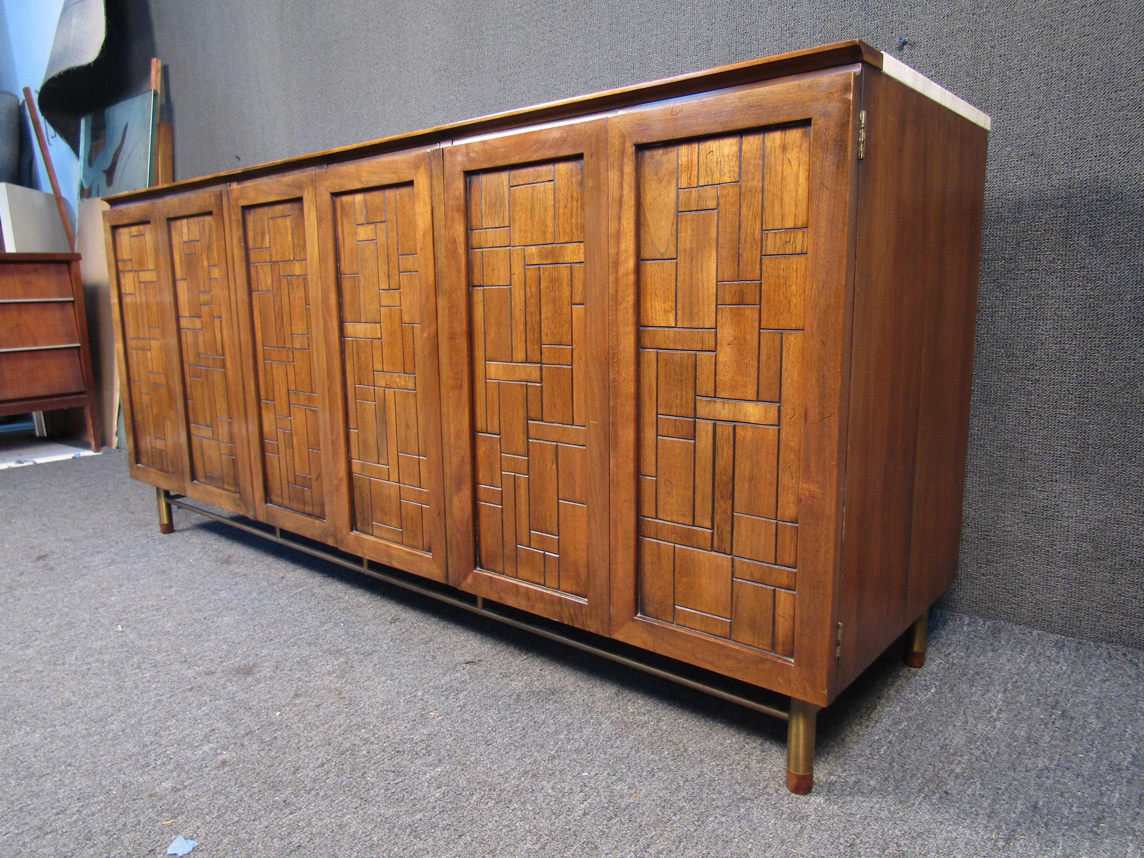 With a metal base, an eye-catching pattern on the doors, and a travertine top, this vintage sideboard by Johnson Handley Furniture Co. is built with Mid-Century Modern quality and style. Please confirm item location with seller (NY/NJ).