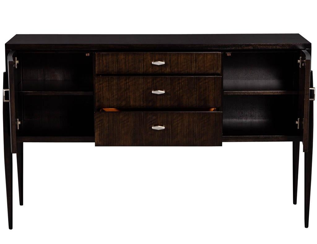 Mid-Century Modern Inspired sideboard cabinet in Zebra wood. Modern espresso finished Zebra wood credenza with turned legs and curved doors ands satin nickel hardware.

Price includes complimentary scheduled curb side delivery service to the
