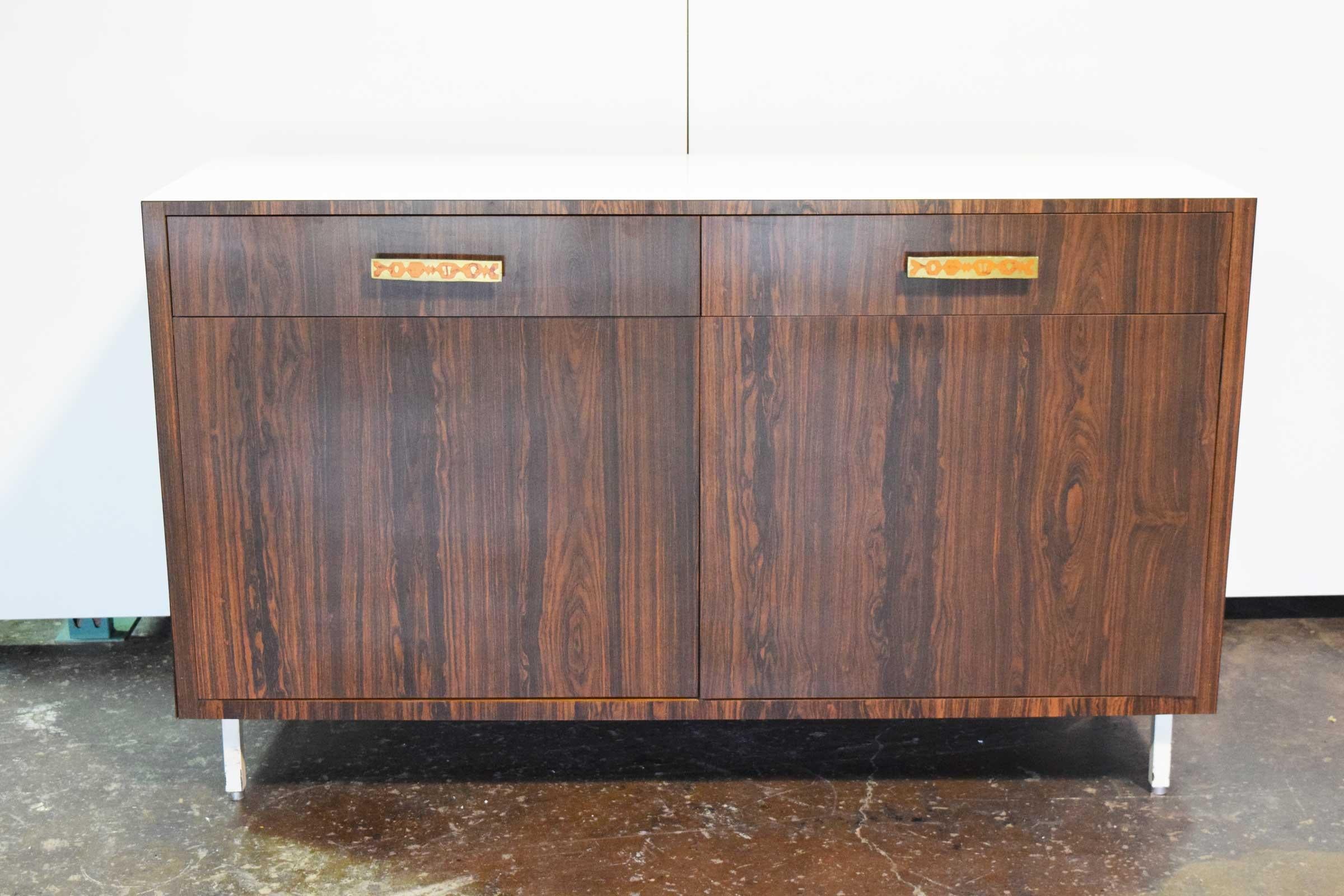 Midcentury sideboard with decorative hardware and white laminate top.