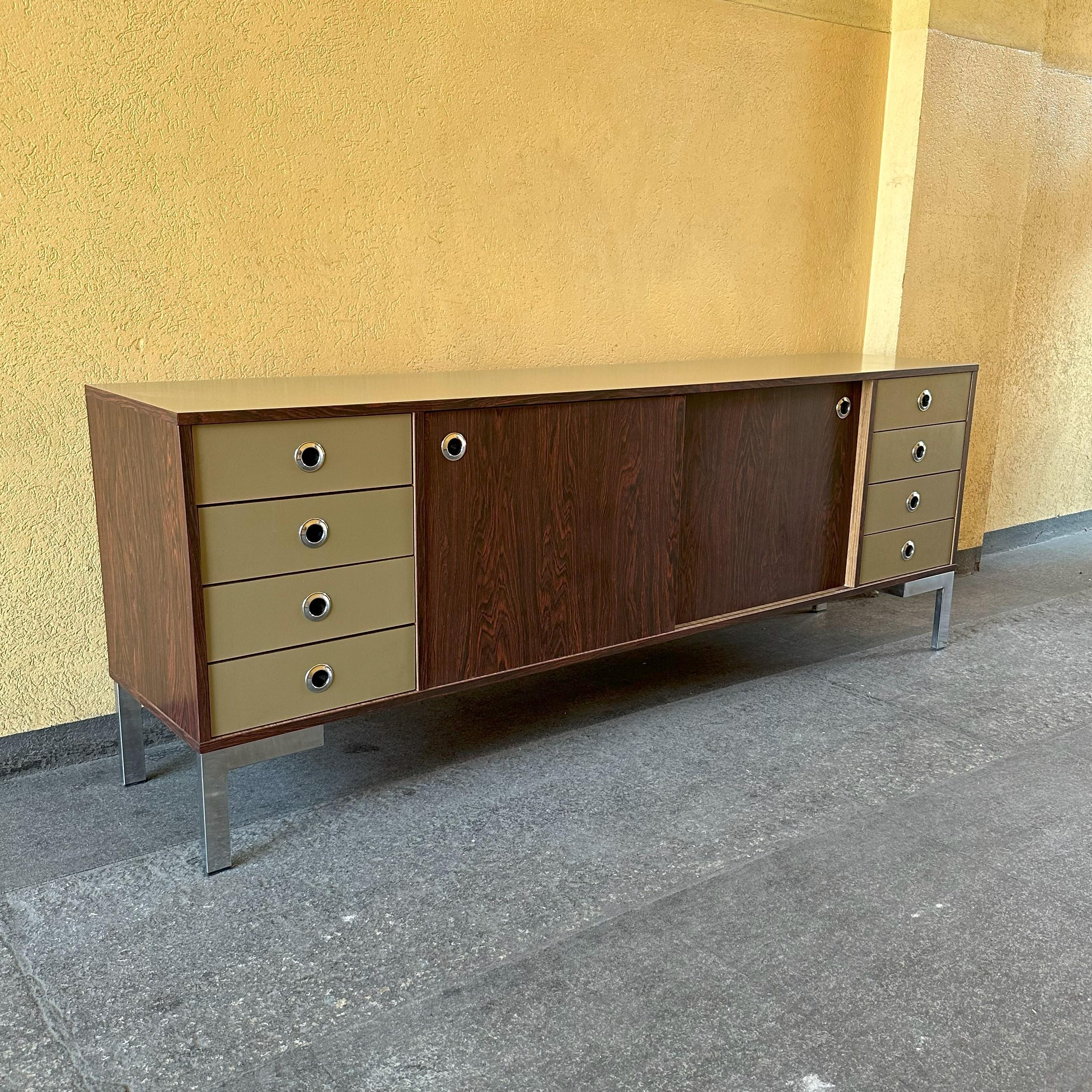 Sideboard from the seventies, Italian manufacture.
Seventies sideboard in laminate, Italian manufacture sideboard has chromed steel legs.
Laminate has a visual effect similar to rosewood
On the sides it has 4 drawers and in the center 2 cabinets