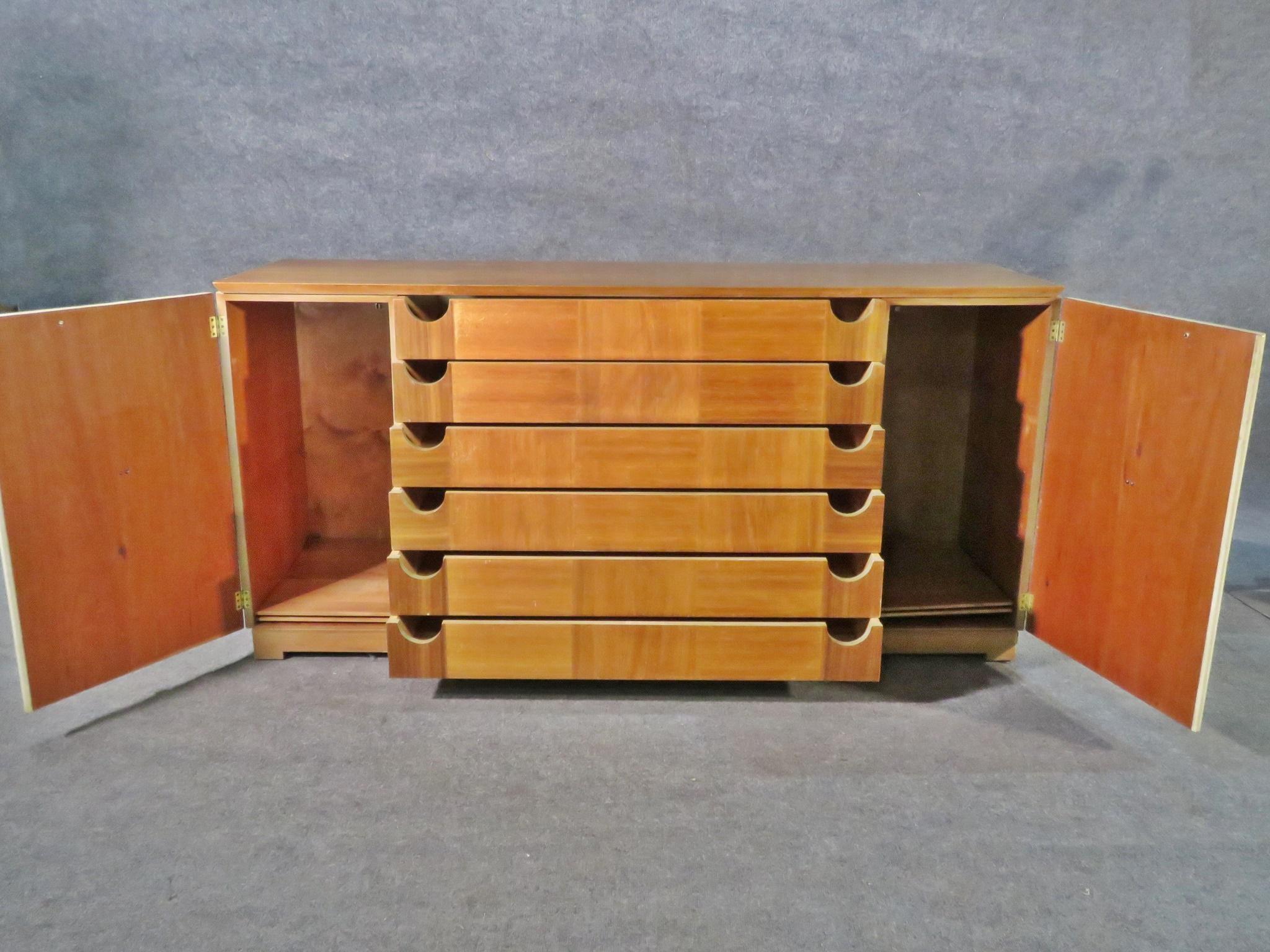 An elegant sideboard styled after Paul Laszlo, this Mid-Century Modern piece offers generous storage through doors containing two shelves and six dovetailed drawers. Please confirm item location with seller (NY/NJ).