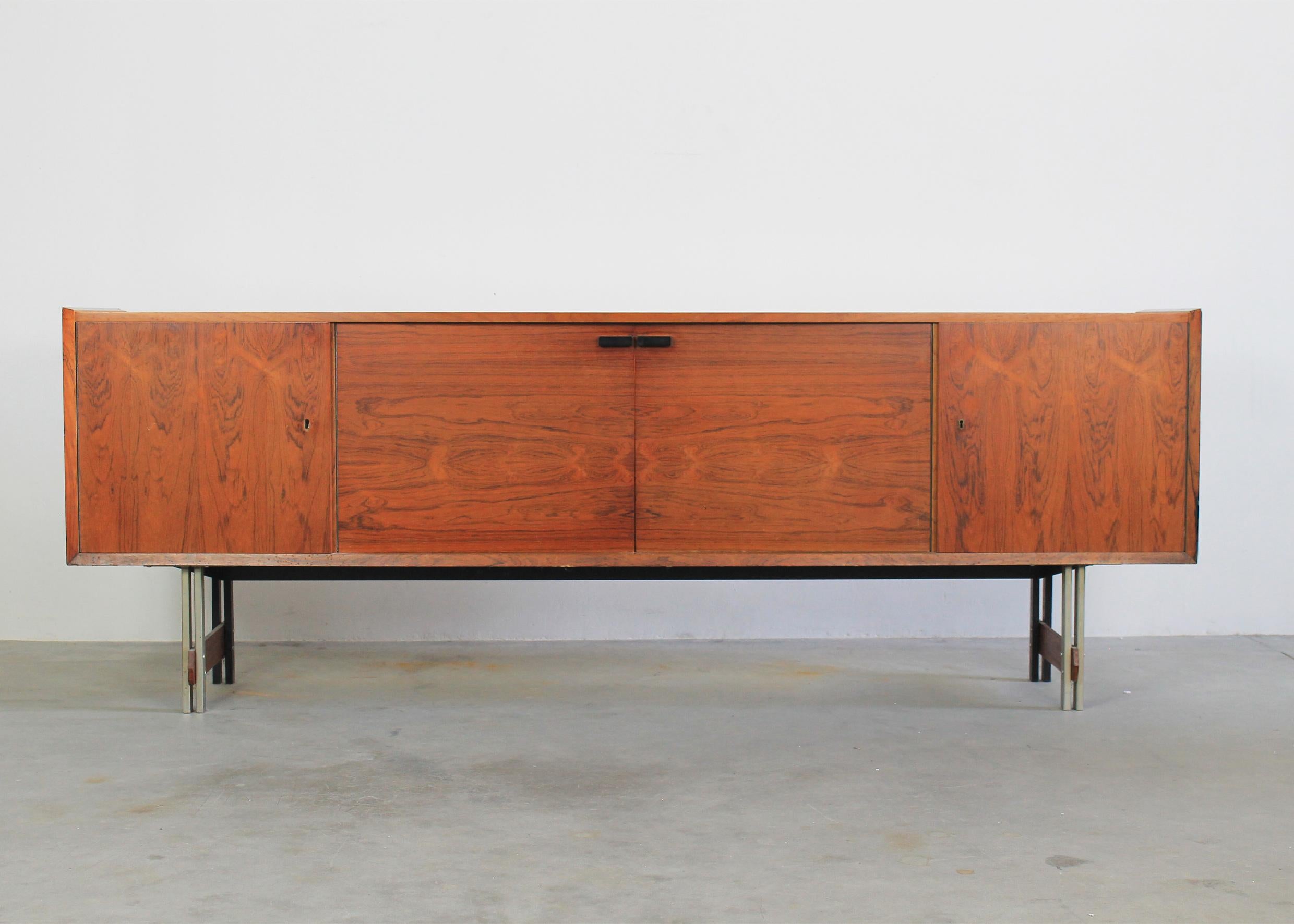 Mid-Century Modern style sideboard with a structure in wood and metal details, the sideboard presents four doors, an inner shelve and drawers. 
Italian manufacture from the 1960s.