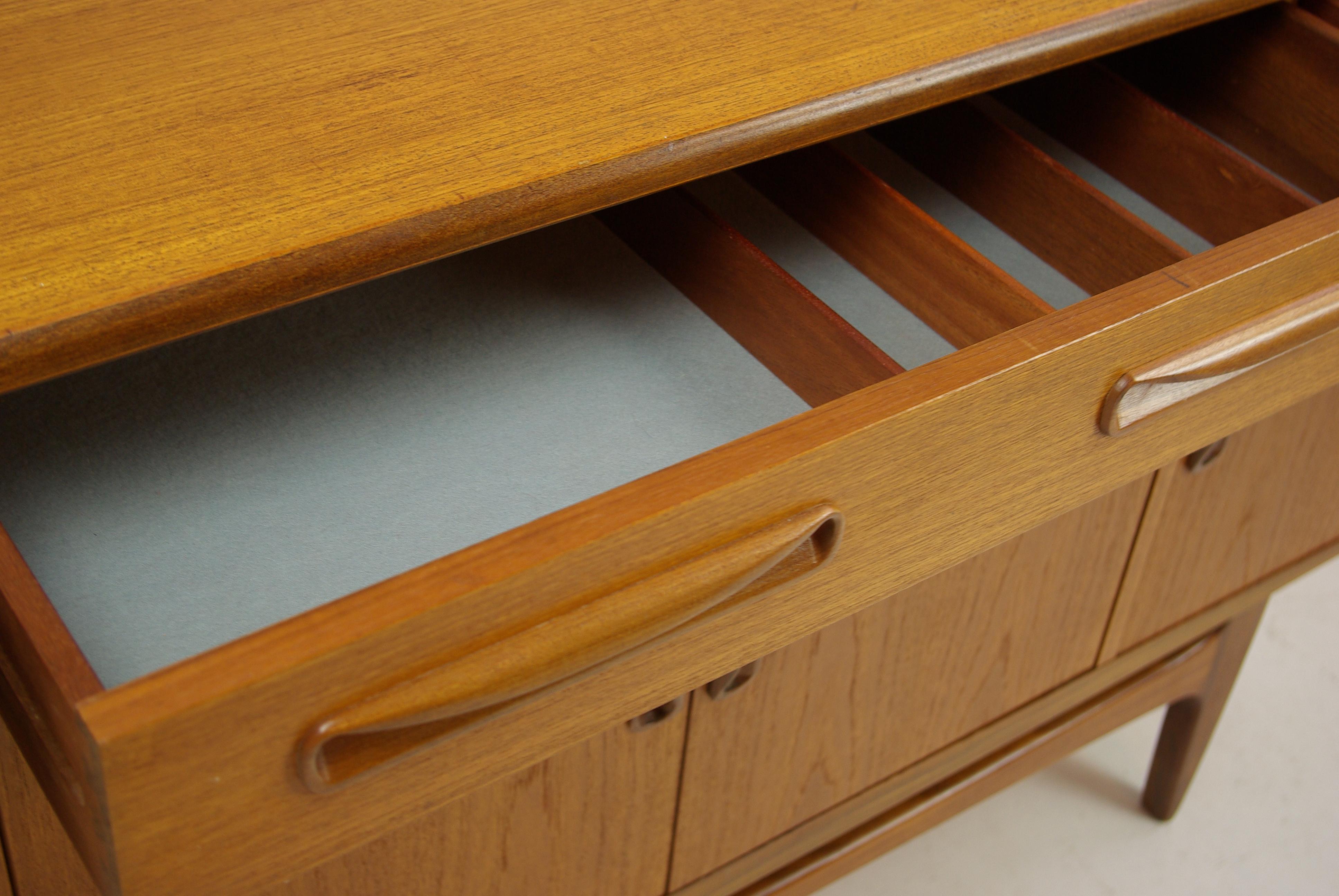 Midcentury sideboard, teak, GPlan, fresco range, England 1950s, antique furniture, B1301.

England 1950s
Solid teak and veneers
Original finish
Rectangular top
Three dovetailed drawers below
Middle drawer with original cutlery