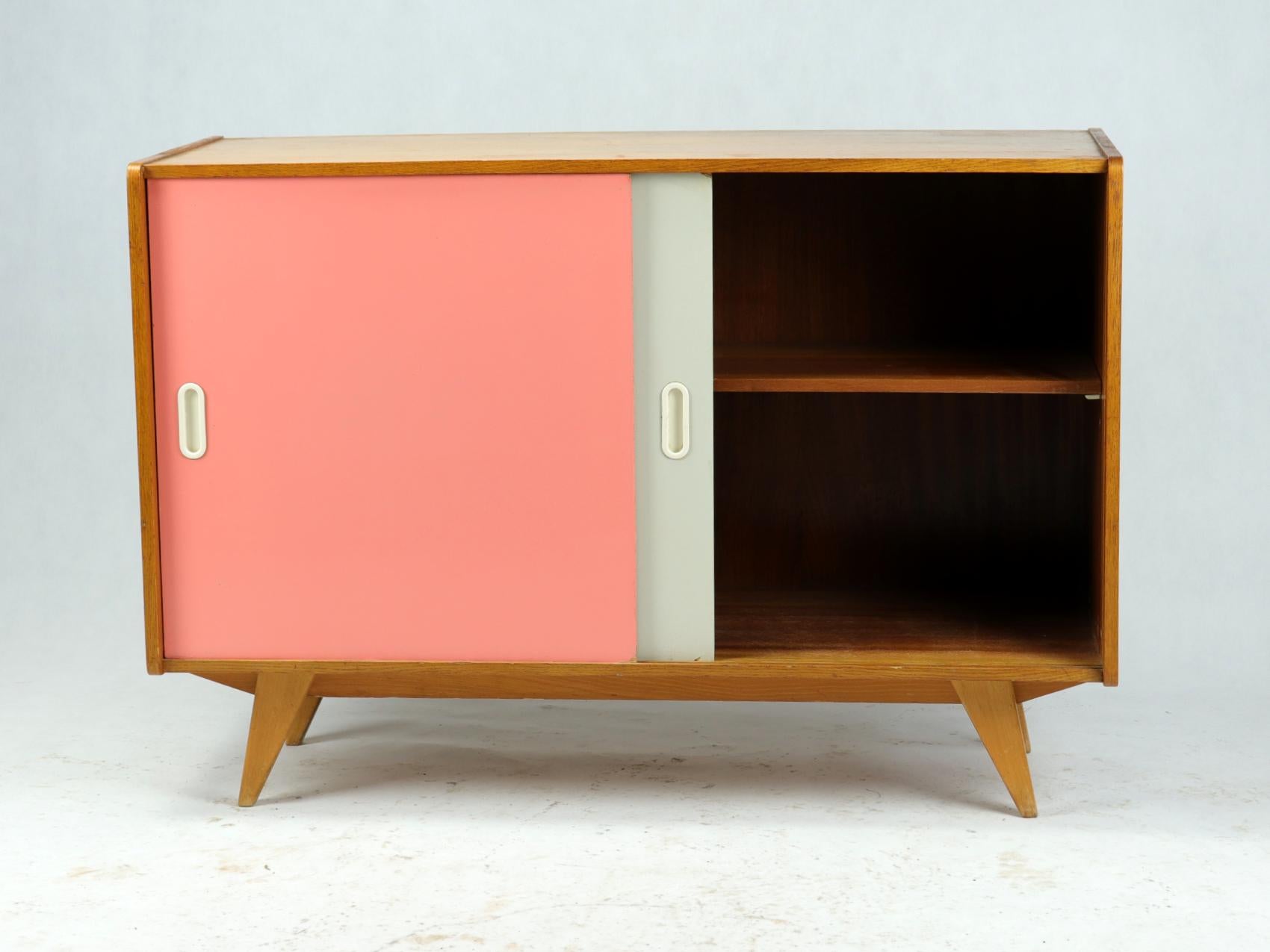 Elegant sideboard typical for the midcentury era in Czechoslovakia. Designed by Jiri Jiroutek in 1960s, this U450 type sideboar has sliding doors. These are iconic for the designer who was the first one to combine classical wooden box with fresh and
