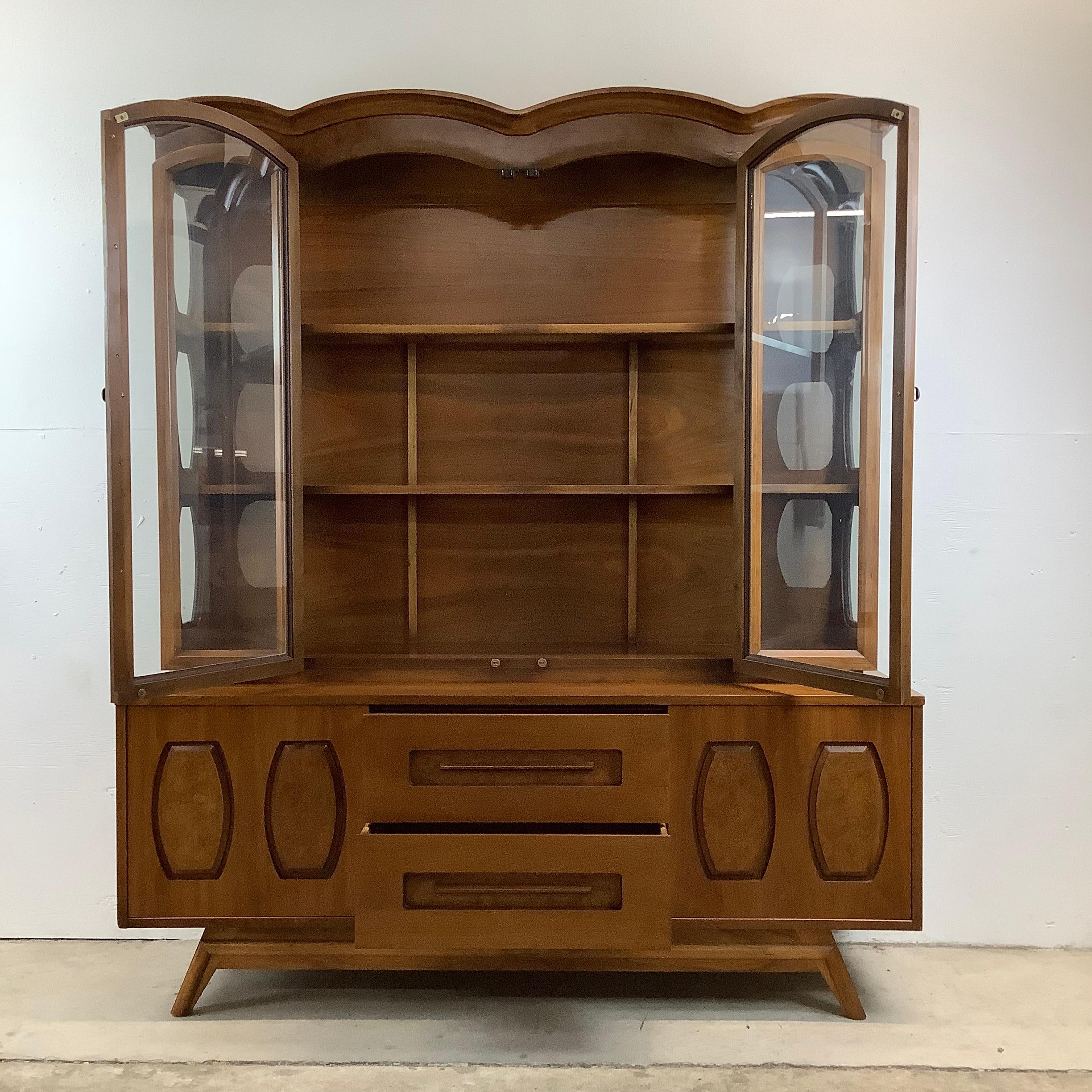 This unique two piece sideboard with china cabinet topper features details decorative design on both the cabinet top and sliding door fronts. Spacious mix of storage and display space, this piece is well suited to use as a dining room buffet or