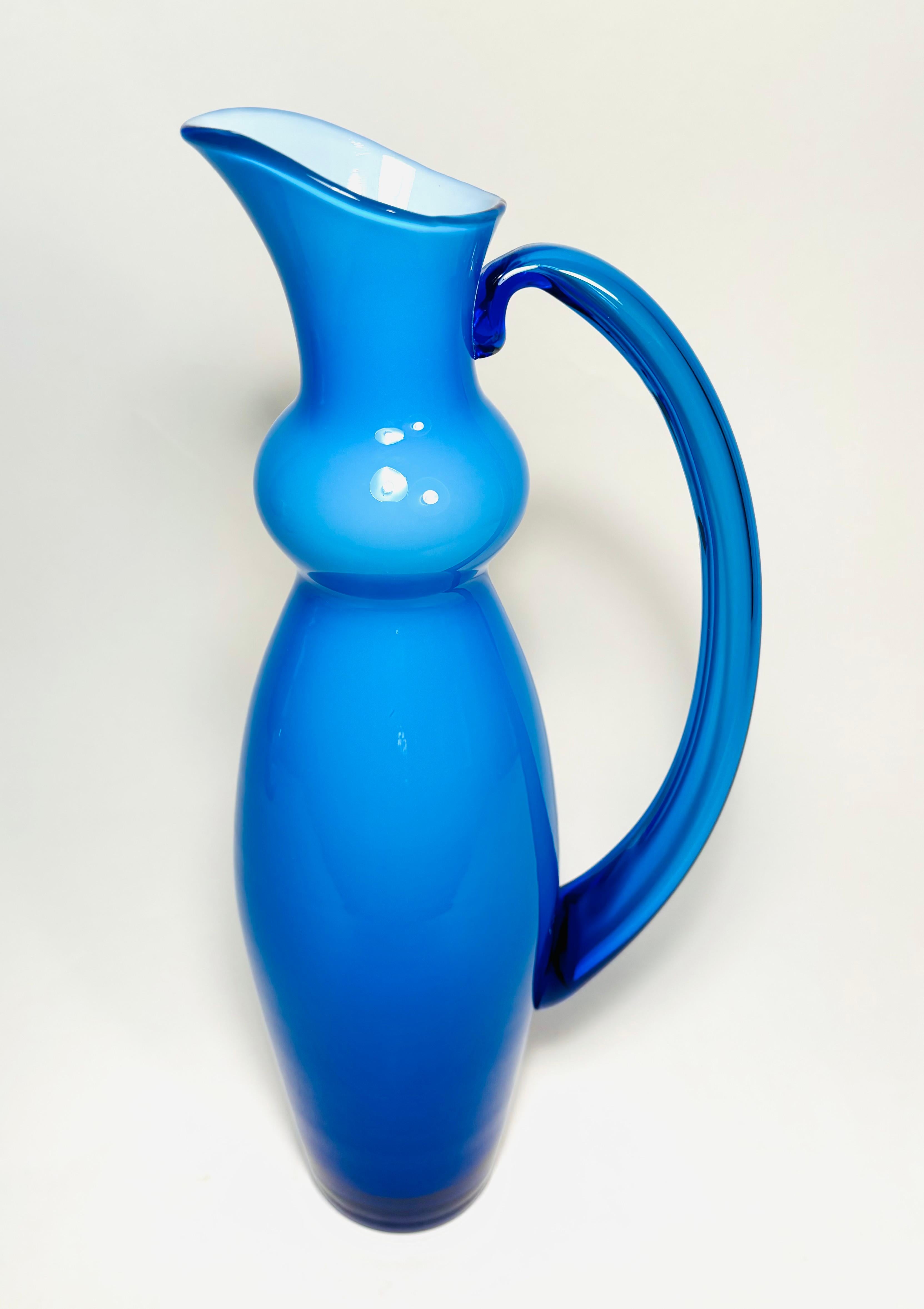 A tall and striking art glass vase by Orrefors, fully hall marked. Cased in a vibrant shade of blue over white this piece is stunning just on its own. In very good vintage condition