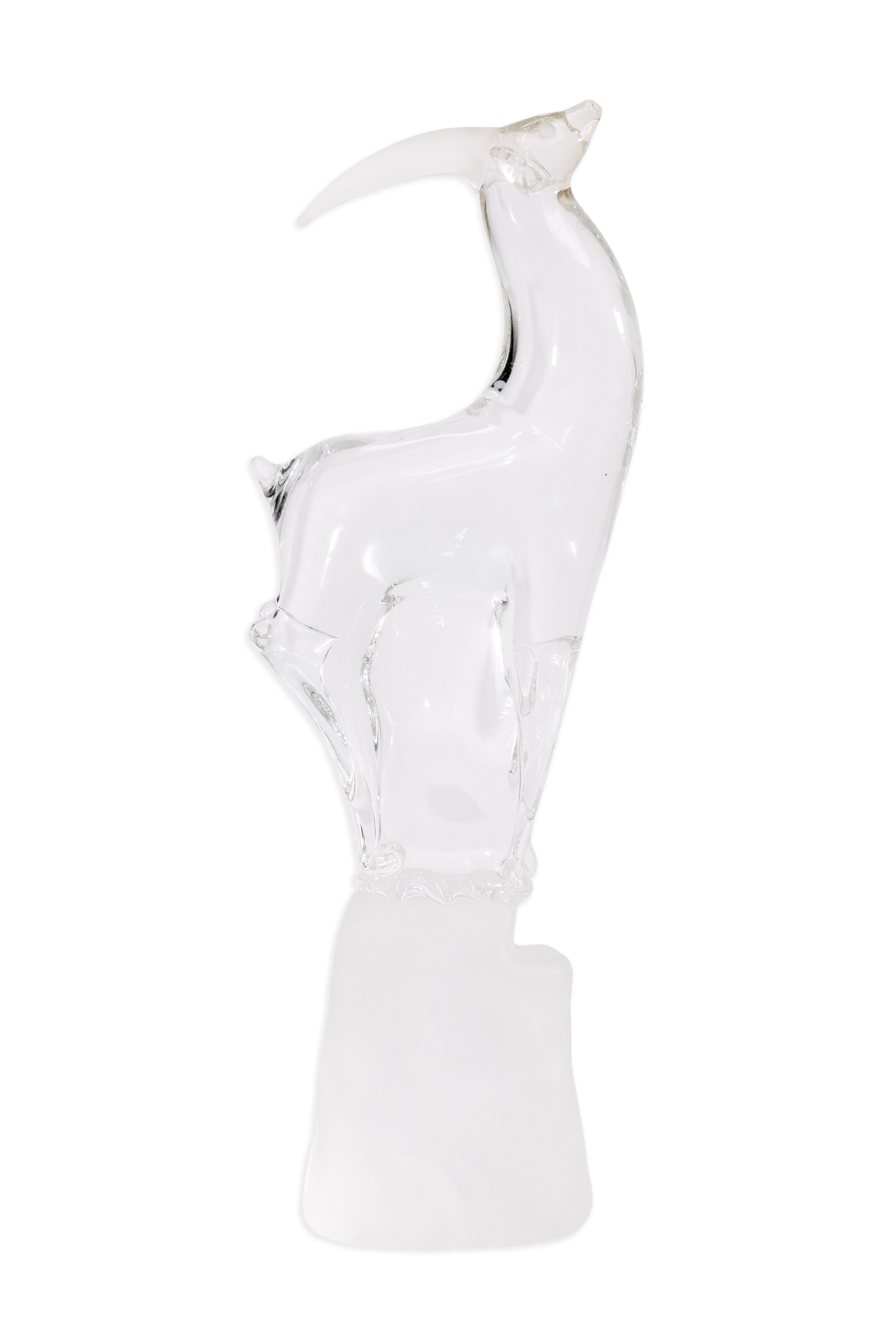  Elegant and refined, this Mid Century Modern signed clear art glass antelope sculpture captures the grace and poise of the animal through a fluid, minimalist form. The clear glass body is beautifully sculpted with elongated lines and curved horns,