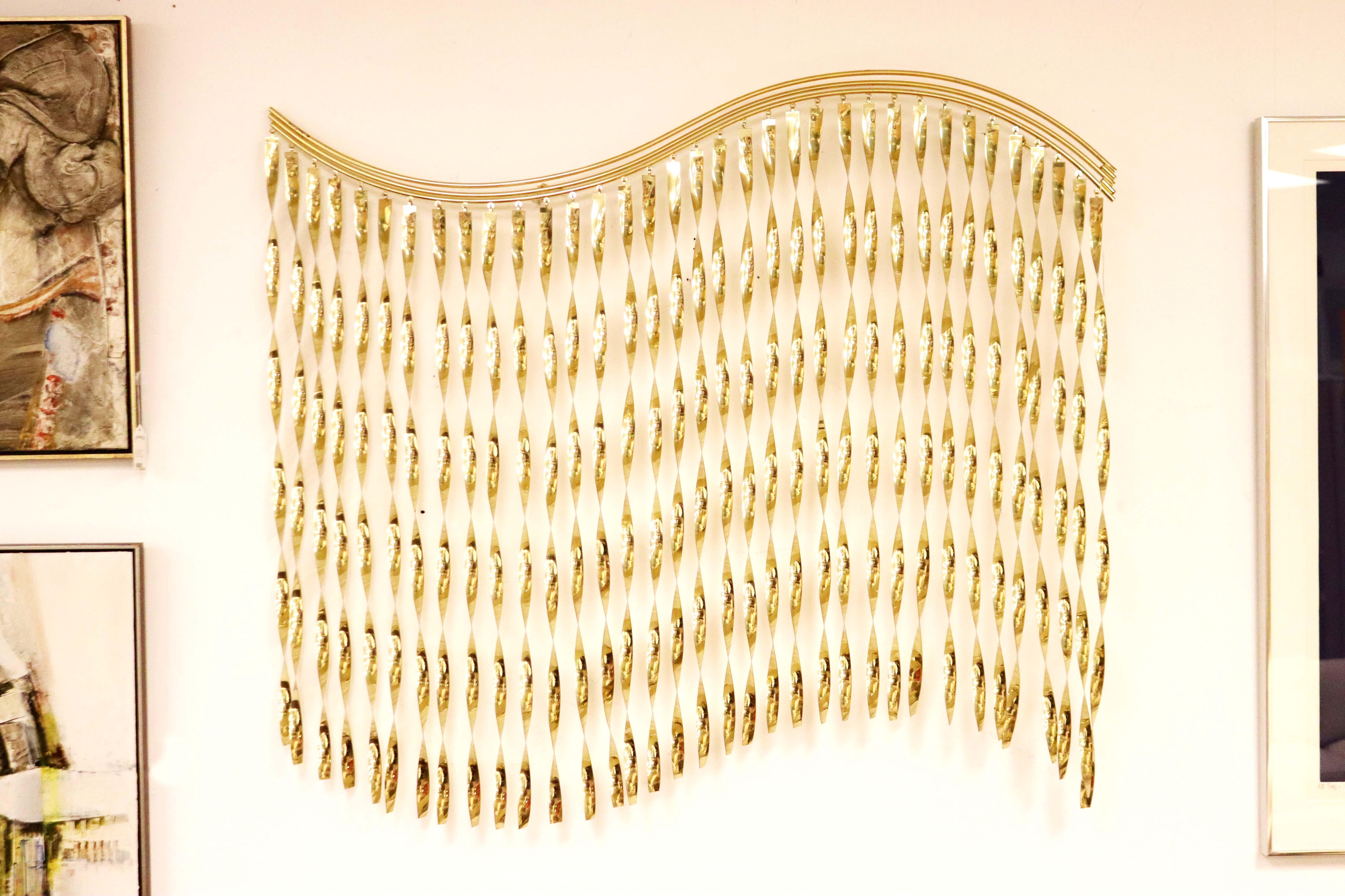 This iconic Curtis Jere kinetic wall sculpture is exemplary of their work and details a wave of flat, gold tone plated ribbons spiraling in undulating form. Magnificent and large scale, this piece measure 47W x 43H and 4D.

Well known to many for