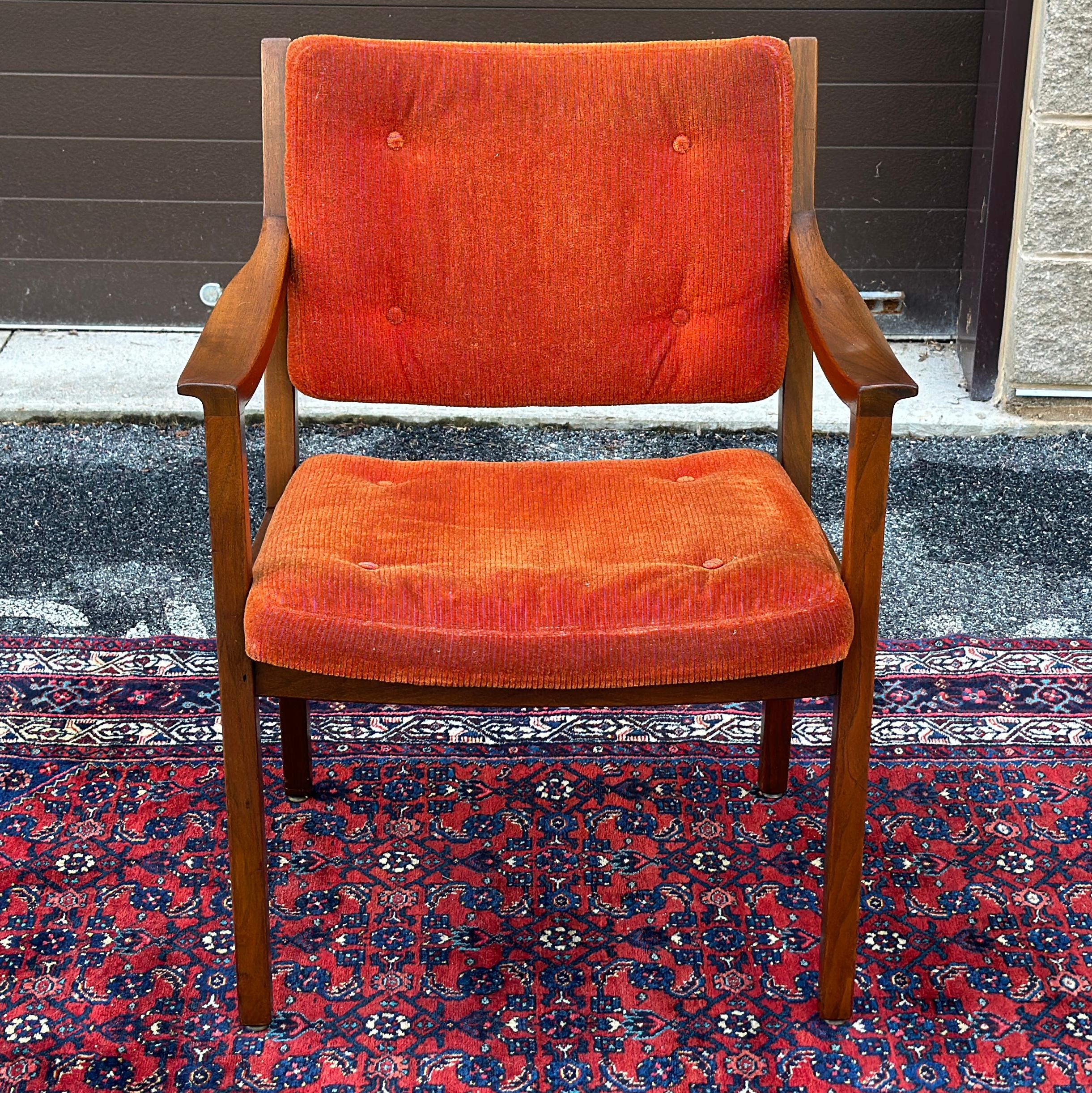 Sedia in noce massiccio Gunlocke con rivestimento arancione e braccioli scolpiti. Firmato con etichetta metallica incastonata nella gamba posteriore e con tutte e tre le Label cartacee. 