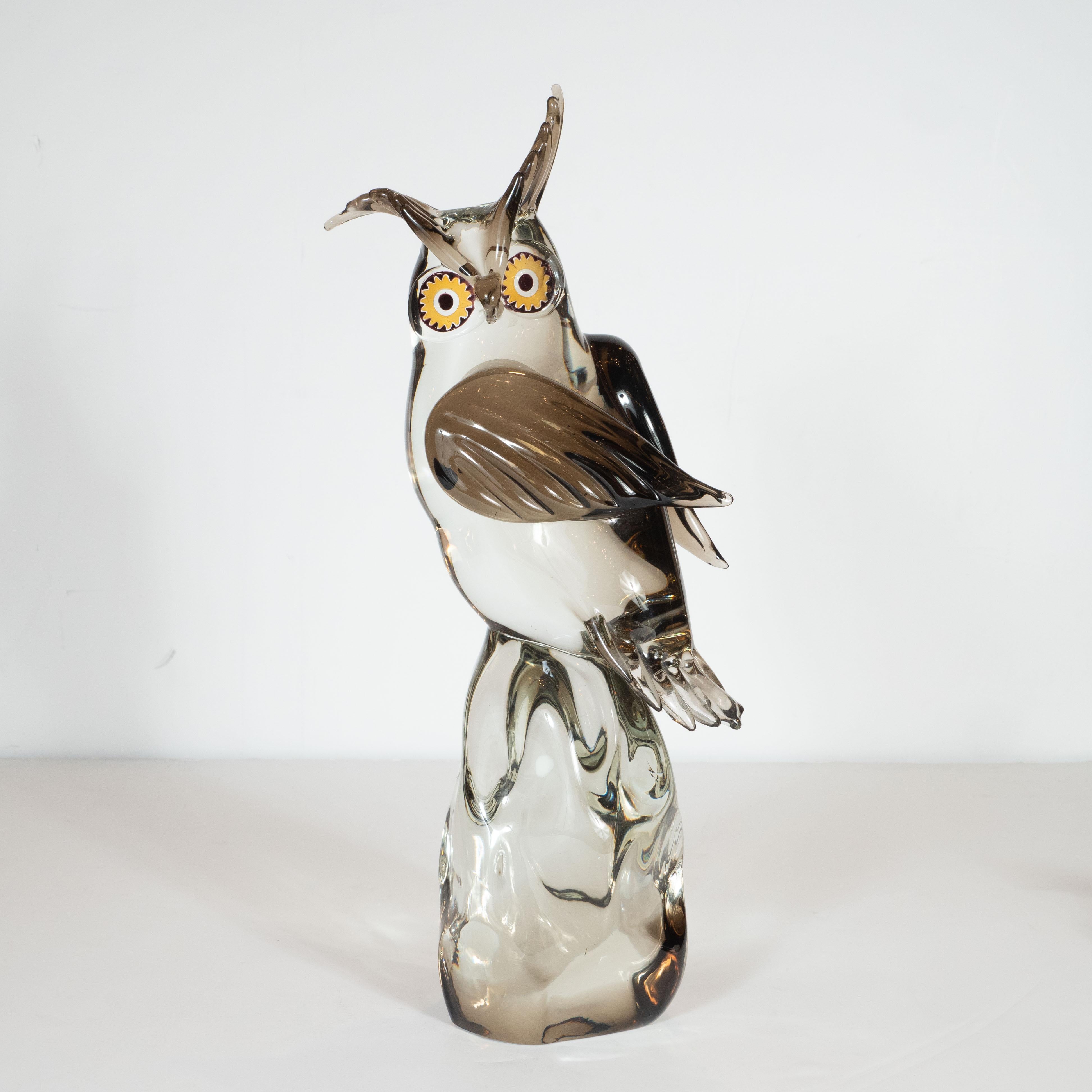 This sophisticated, yet whimsical, Mid-Century Modern owl sculpture was hand blown in Murano, Italy by the master glass maker himself- Licio Zanetti, circa 1960. The sculpture presents an owl perched on an organically contoured translucent base. The