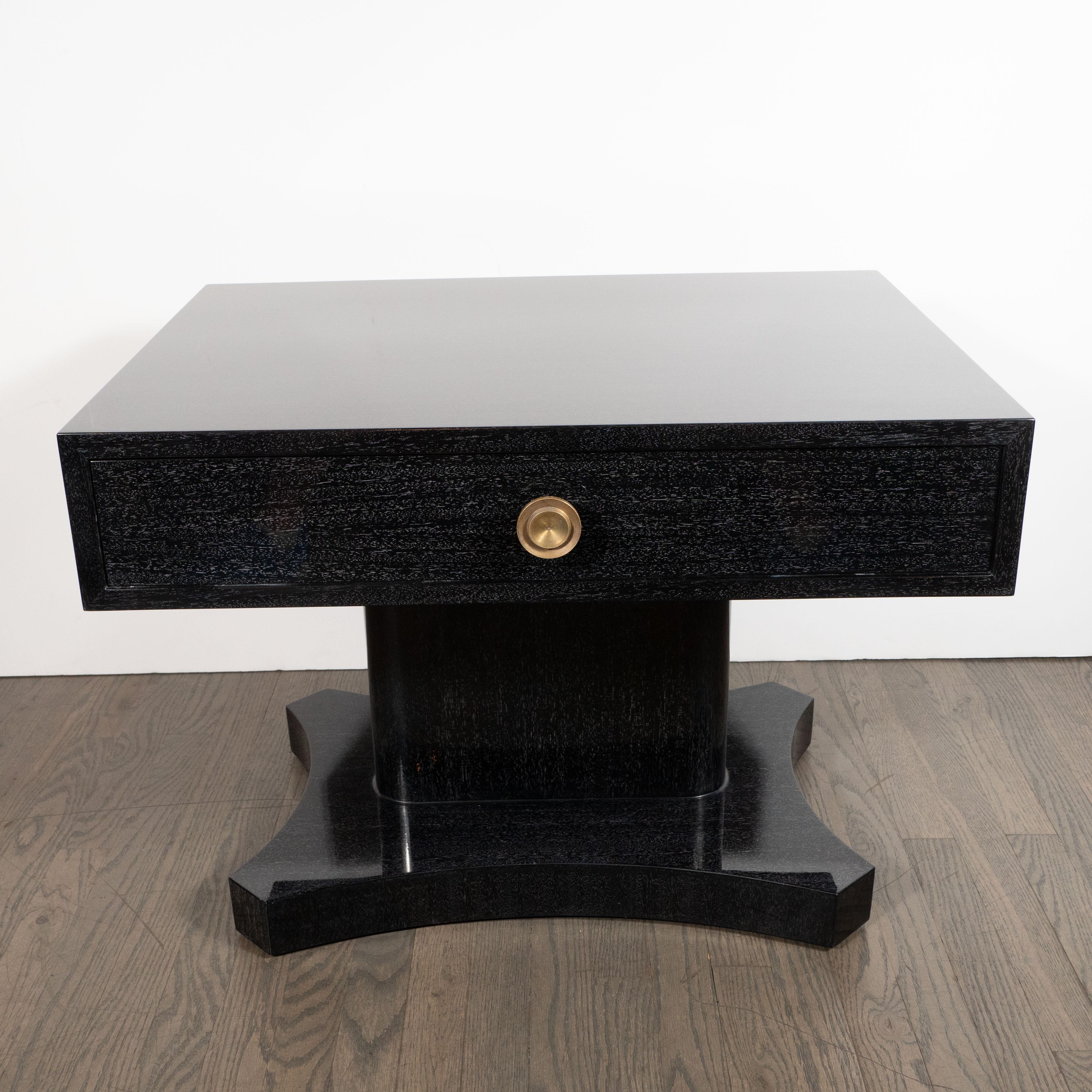 This showstopping pair of end tables/nightstands were realized in the United States, circa 1950. Composed of bleached and silver cerused mahogany, they offer a rectangular drawer with a circular bronze pull with a concentric circular detail in its