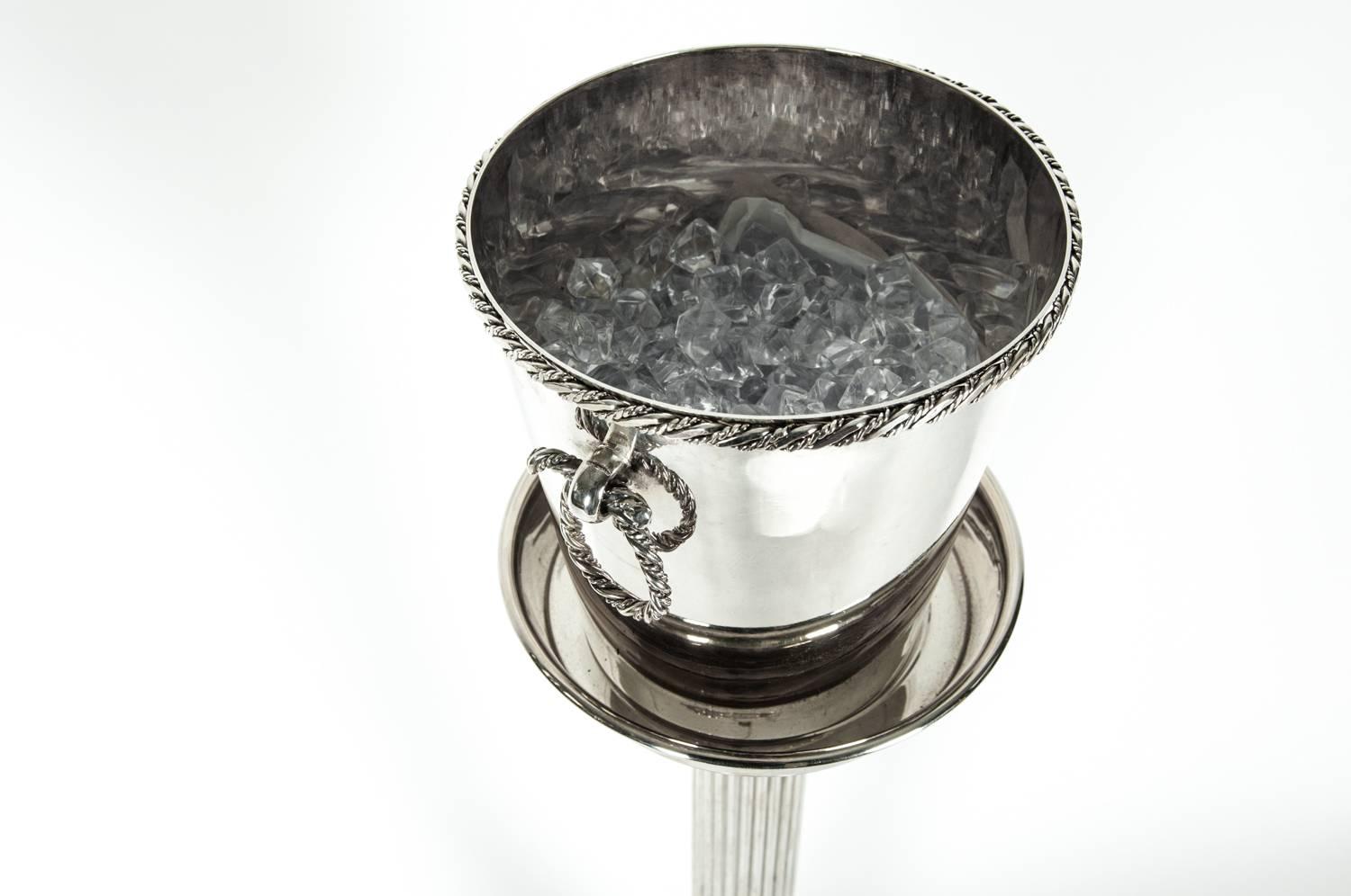 Mid-Century Modern silver plate ice bucket/wine cooler by Christian Dior manufactured in France, circa 1960s with stand. The ice bucket measure 8 inches high X 7.5 inches top diameter. Maker's mark undersigned. The stand's by Birks measure about 25