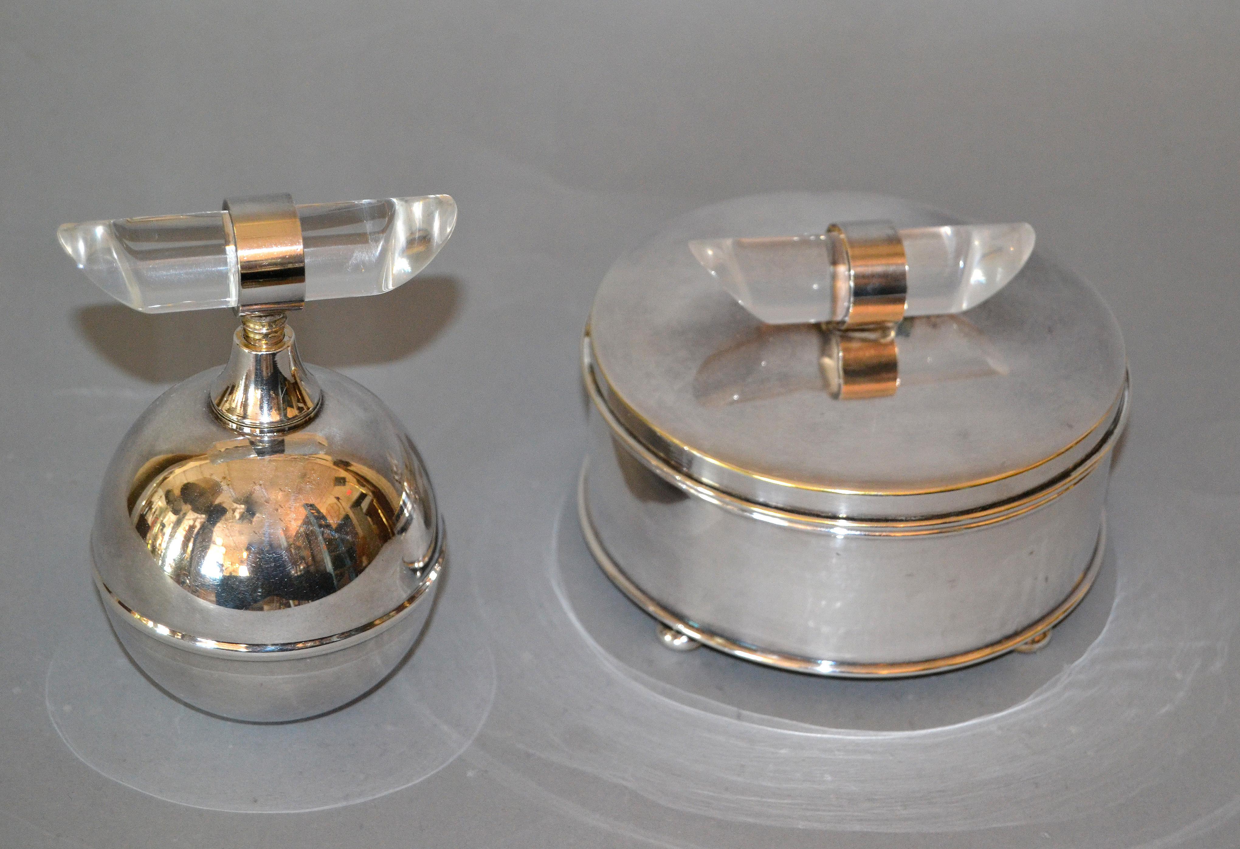 Elegant set de vanité Mid-Century Modern comprenant un flacon de parfum en métal argenté et un bol en verre avec une boîte à poudre en métal argenté.
Le bouton en Lucite, fabriqué à la main, décore les deux pièces.
Marqué sous Apollo et Apollo A