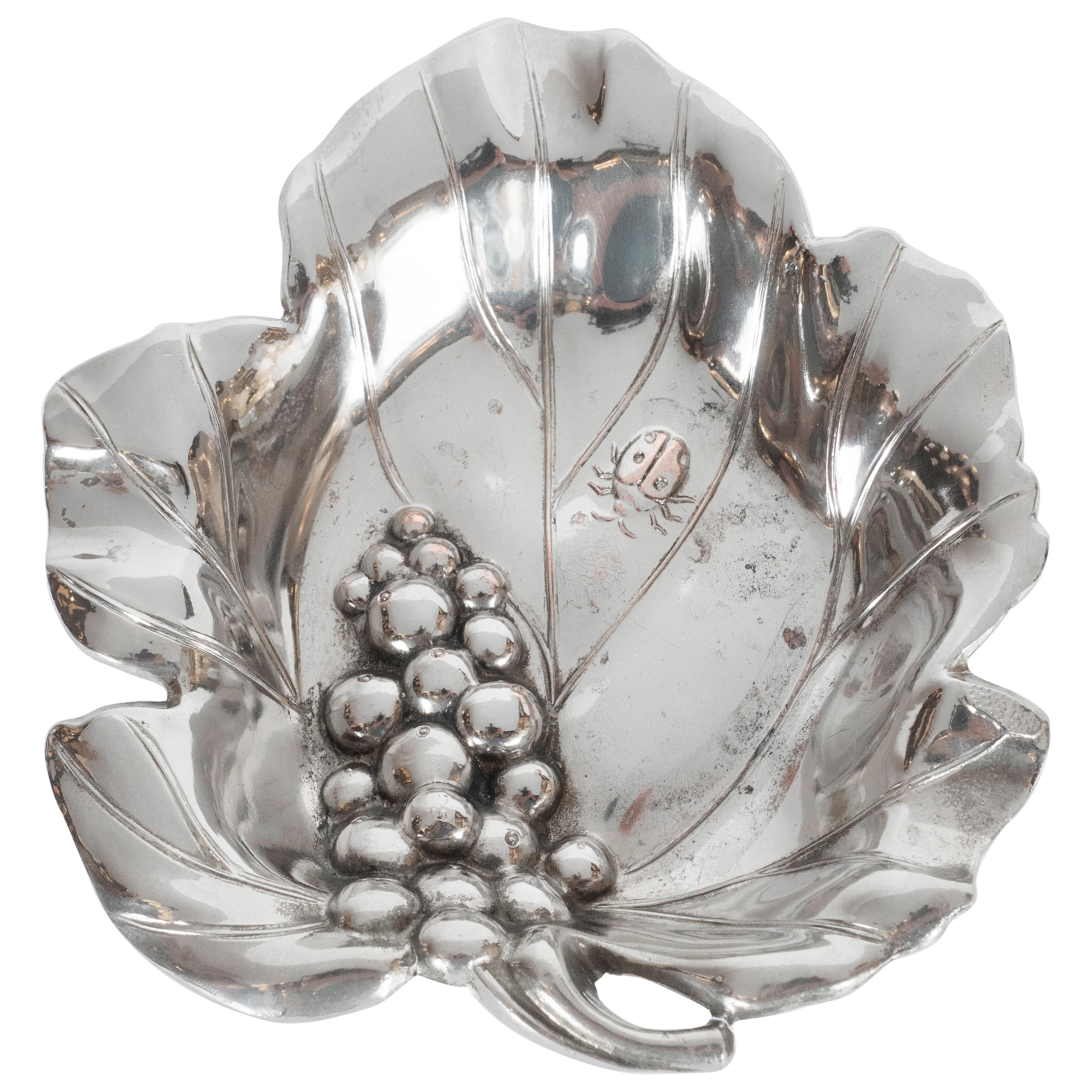 This refined Mid-Century Modern silver plate decorative dish was realized in the United States circa 1960. Offering the form of a stylized grape leaf with pointed scalloped sides and curving lines throughout the interior representing the veins of