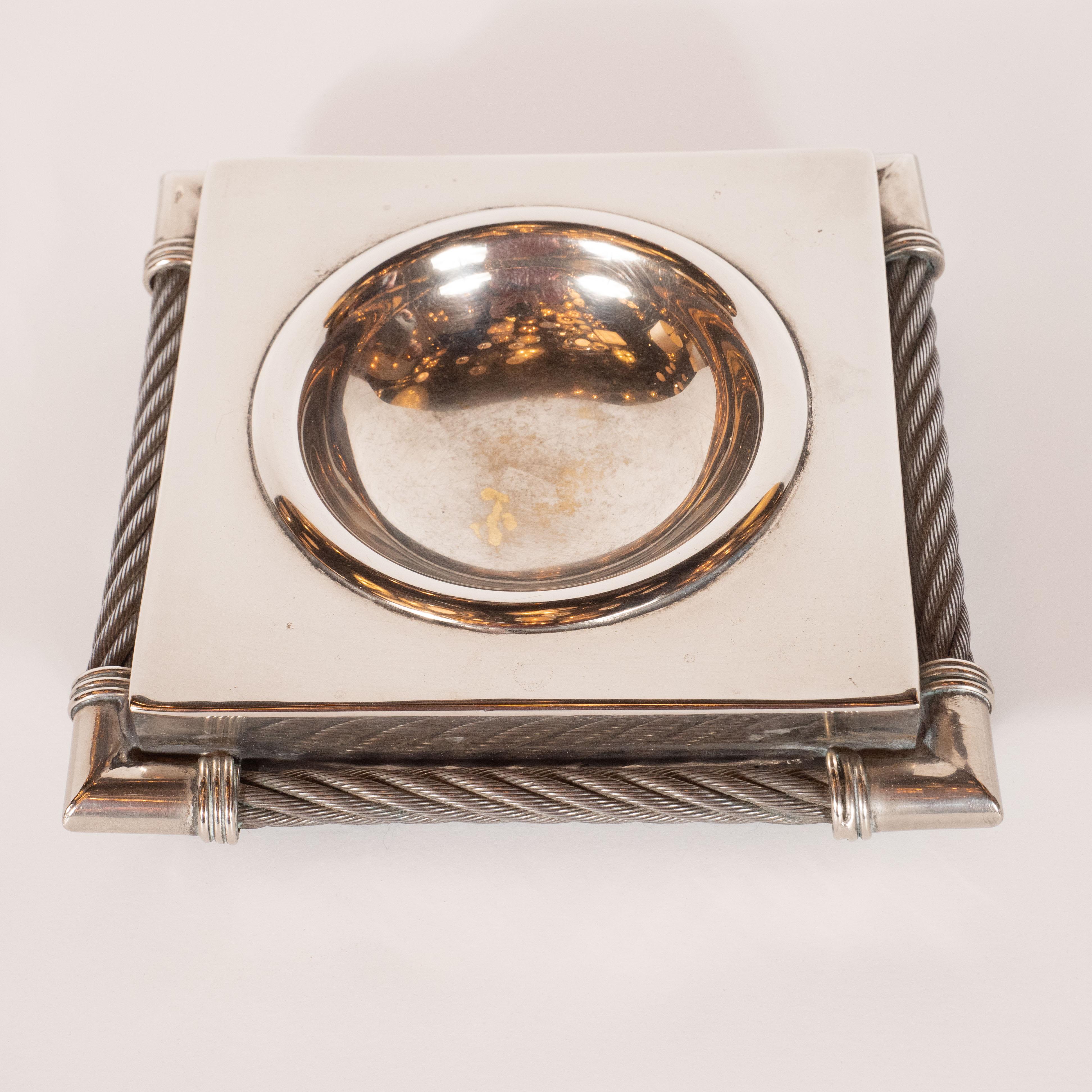 This handsome and refined Mid-Century Modern decorative bowl/ catch all was realized by Christian Dior- one of the most storied fashion and design firms in France's history- circa 1970. It offers a square body with a circular depression in the