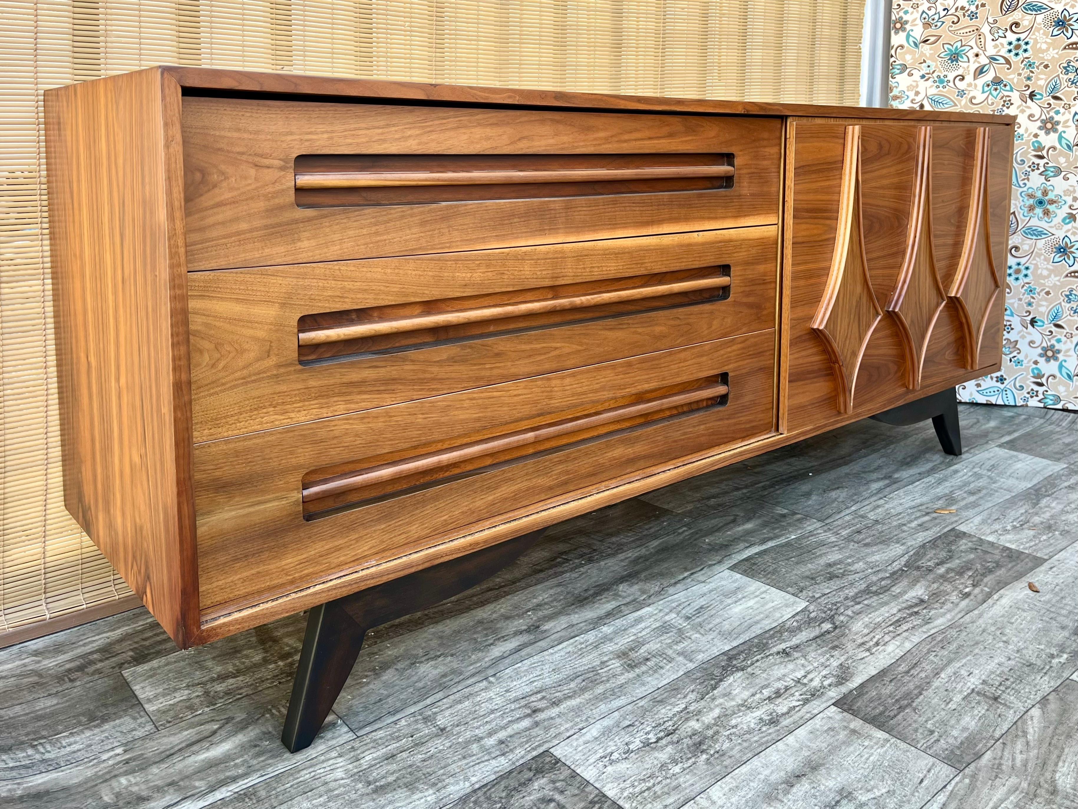 Vintage Fully Restored Mid Century Modern Six Drawers Credenza by Young Manufacturing. Circa 1960s
Features a quintessential Mid Century Modern sleek Design, with three large exposed drawers and three drawers hidden behind a sliding door with a