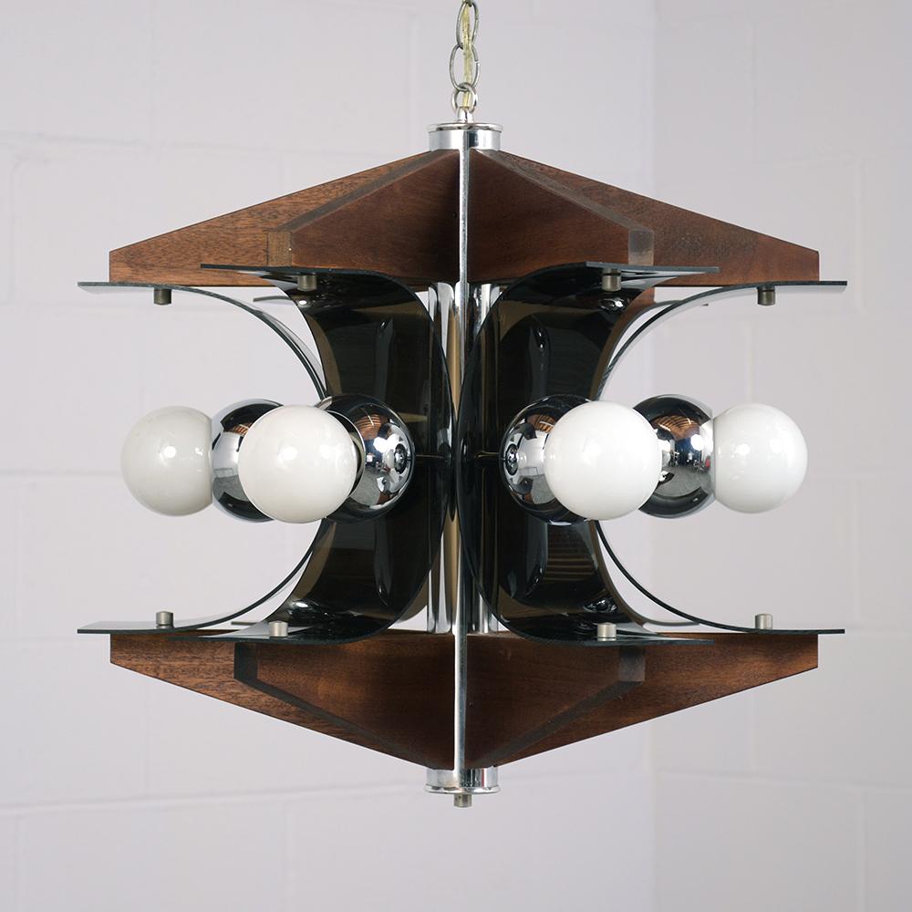 This 1960s Mid-Century Modern chandelier is made of wood with smoked plastic and chrome accents. The top and bottom of the chandelier is finished in a walnut color stained wood. Connecting the wood pieces are curved plastic arcs with the six