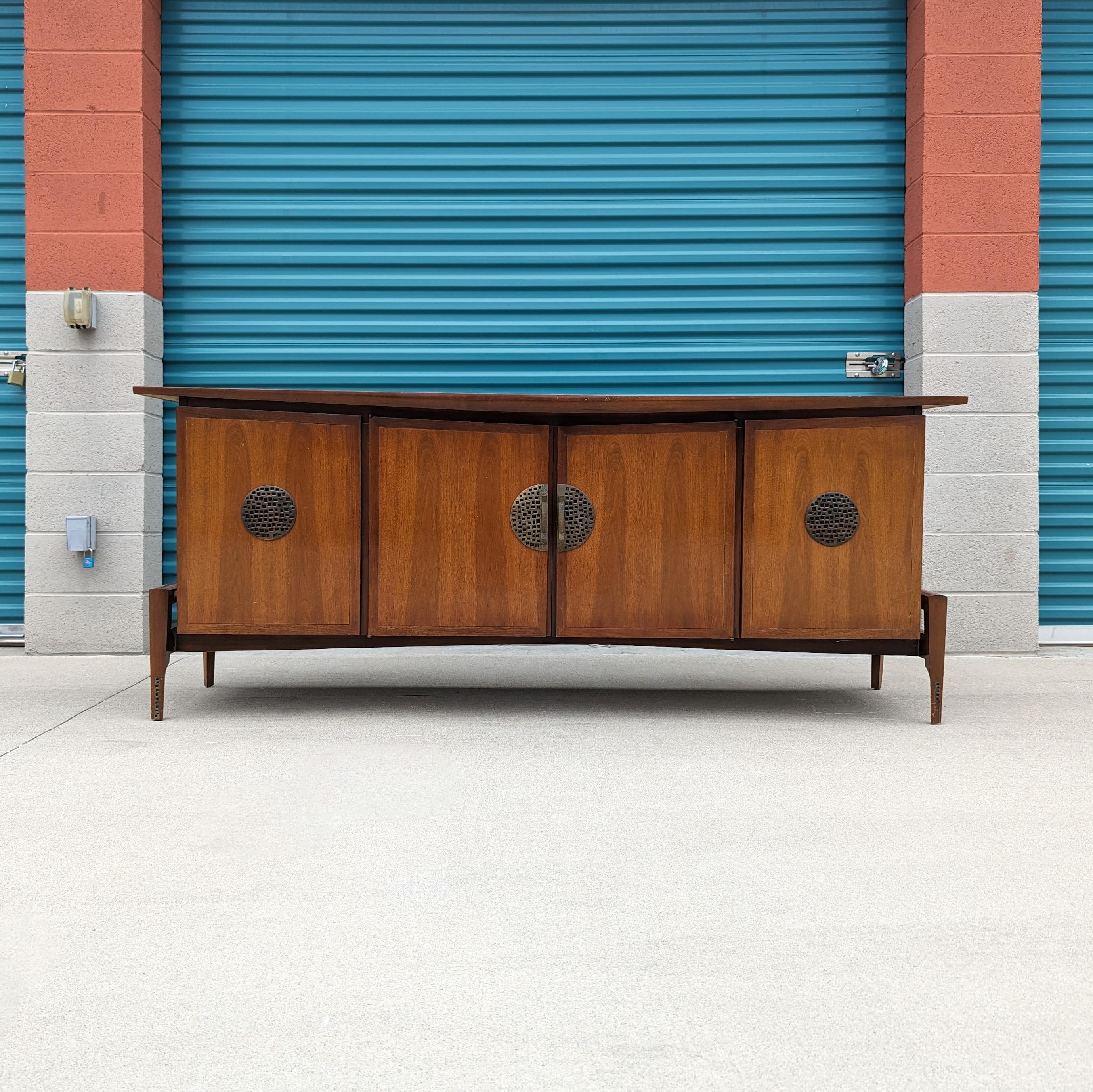 Just in, a walnut and bronze credenza by Helen Hobey for Baker, c1960s. This piece is in original condition and features a walnut finish with a skeletal base making it almost seem like it's suspended in air. Four doors total that open up to expose
