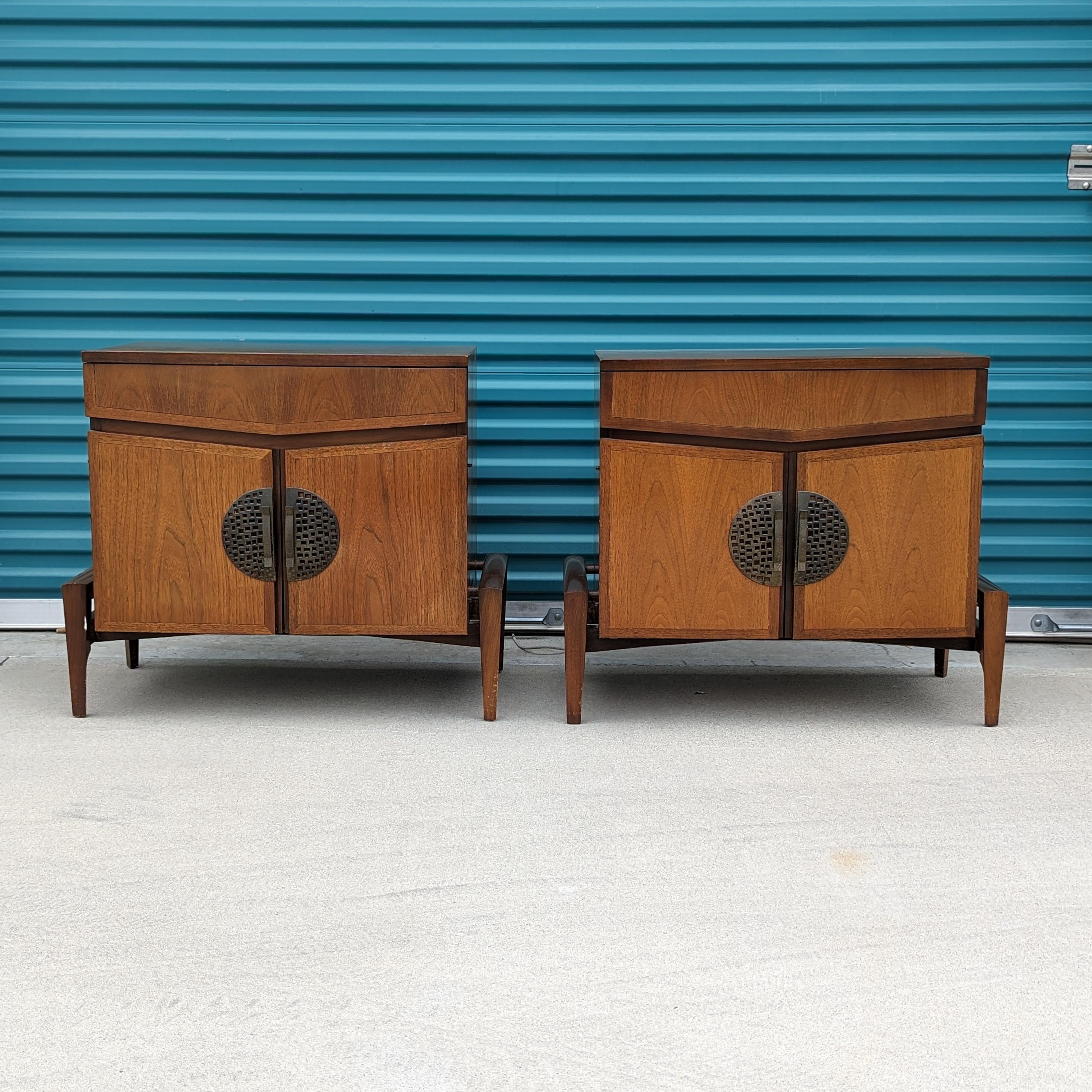 Just in, a walnut and bronze nightstands by Helen Hobey for Baker, c1960s. This pair is in original condition and features a walnut finish with a skeletal base making them seem like they're suspended in air. Two doors on each that open up to expose